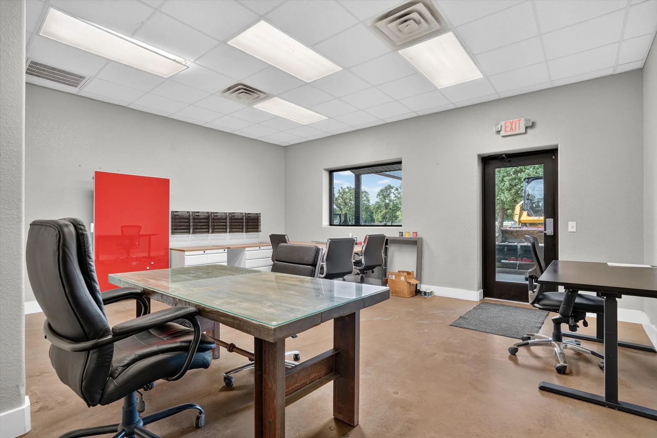 Spacious interior workspace with light gray walls and a drop ceiling with recessed lighting
