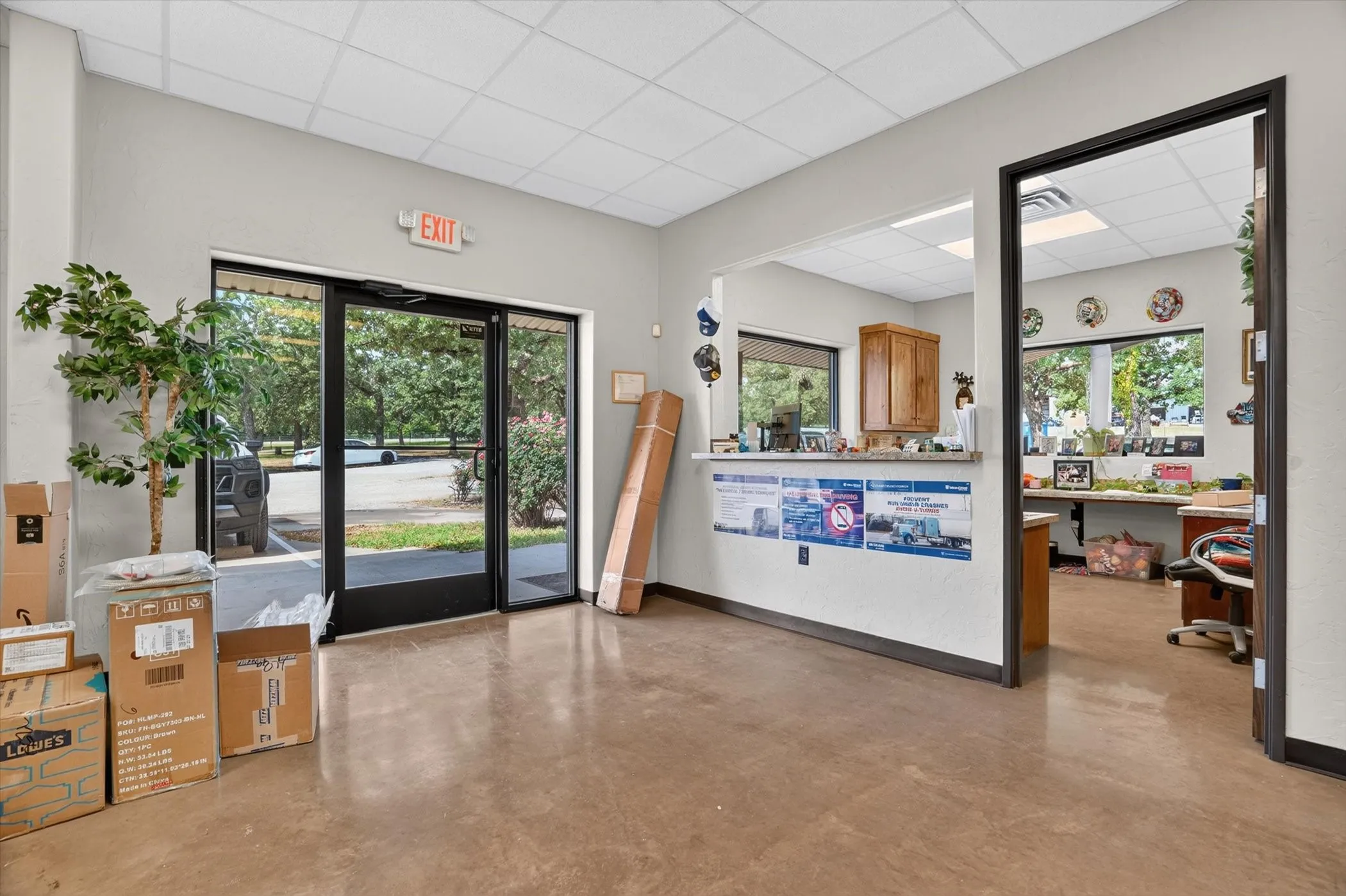Spacious commercial entry with full-light double doors and sidelights, polished concrete flooring, and a drop ceiling with recessed lighting