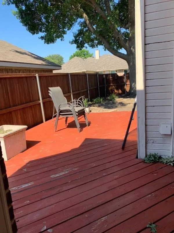 Spacious outdoor deck featuring red-toned wood-finish planks