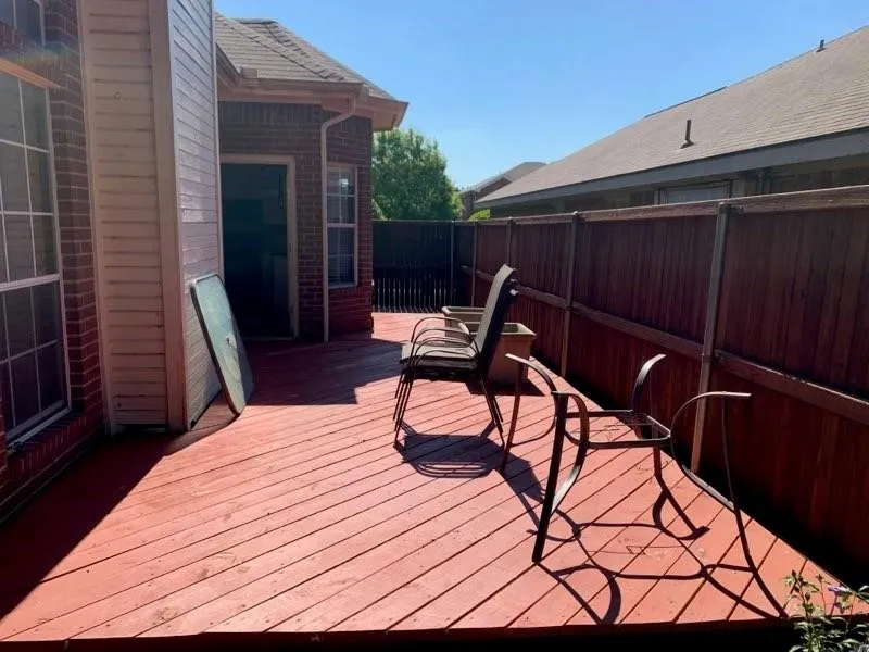 Expansive outdoor deck featuring wood flooring and a perimeter privacy fence