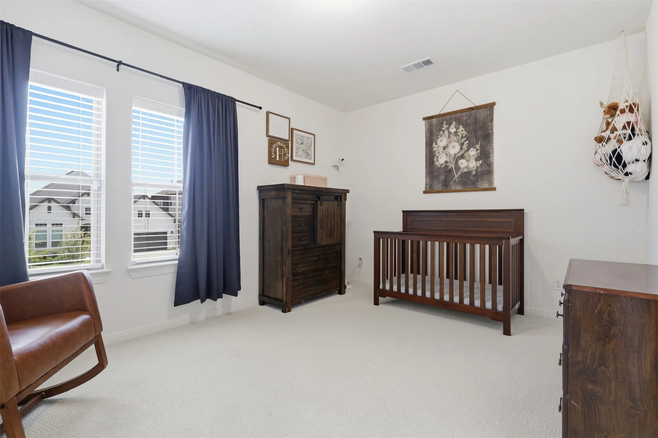 Bright interior space featuring two large windows with horizontal blinds and full-length privacy drapes