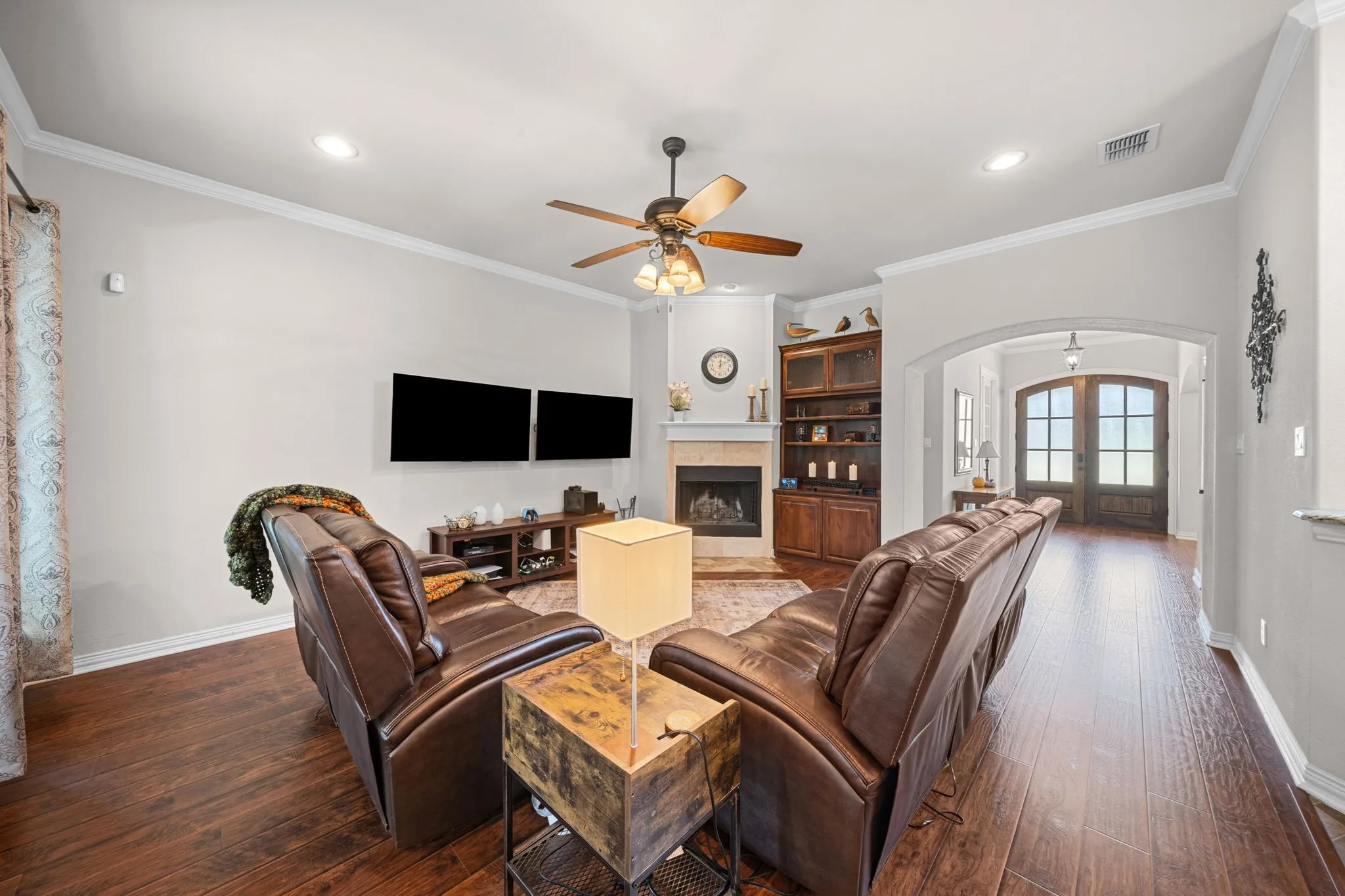 Living area boasts built-ins with glass-front cabinets.