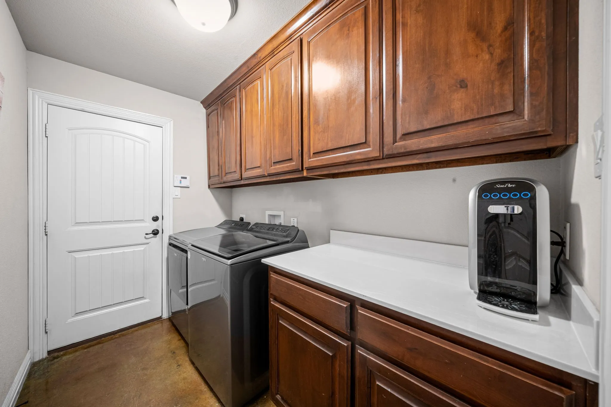 Utility room features cabinets and a folding area.