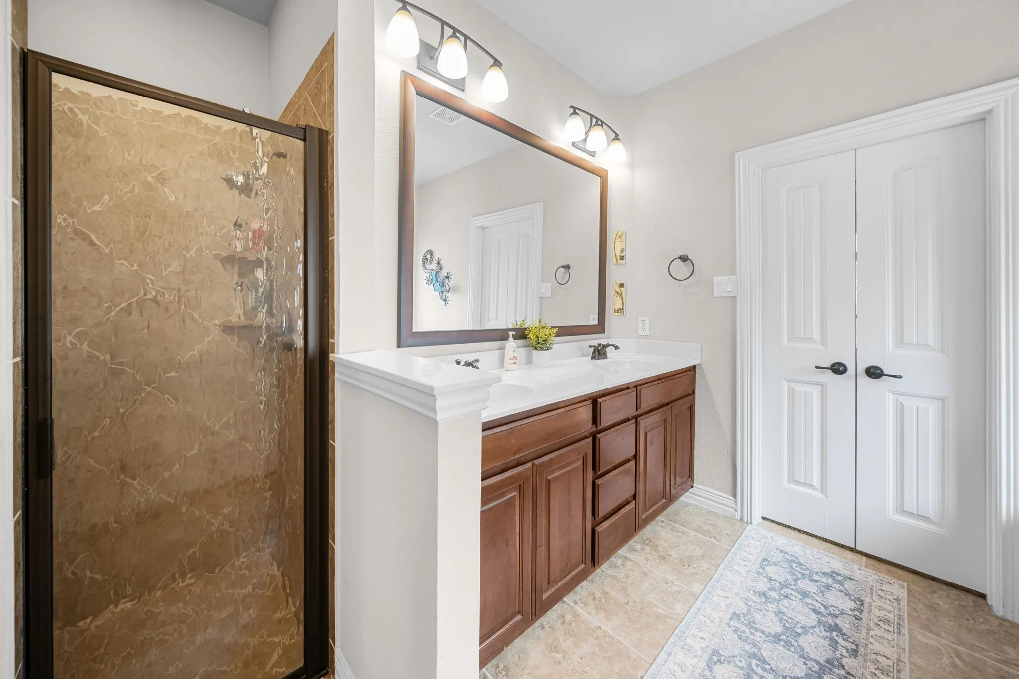 Primary bath with dual sinks and a large vanity.
