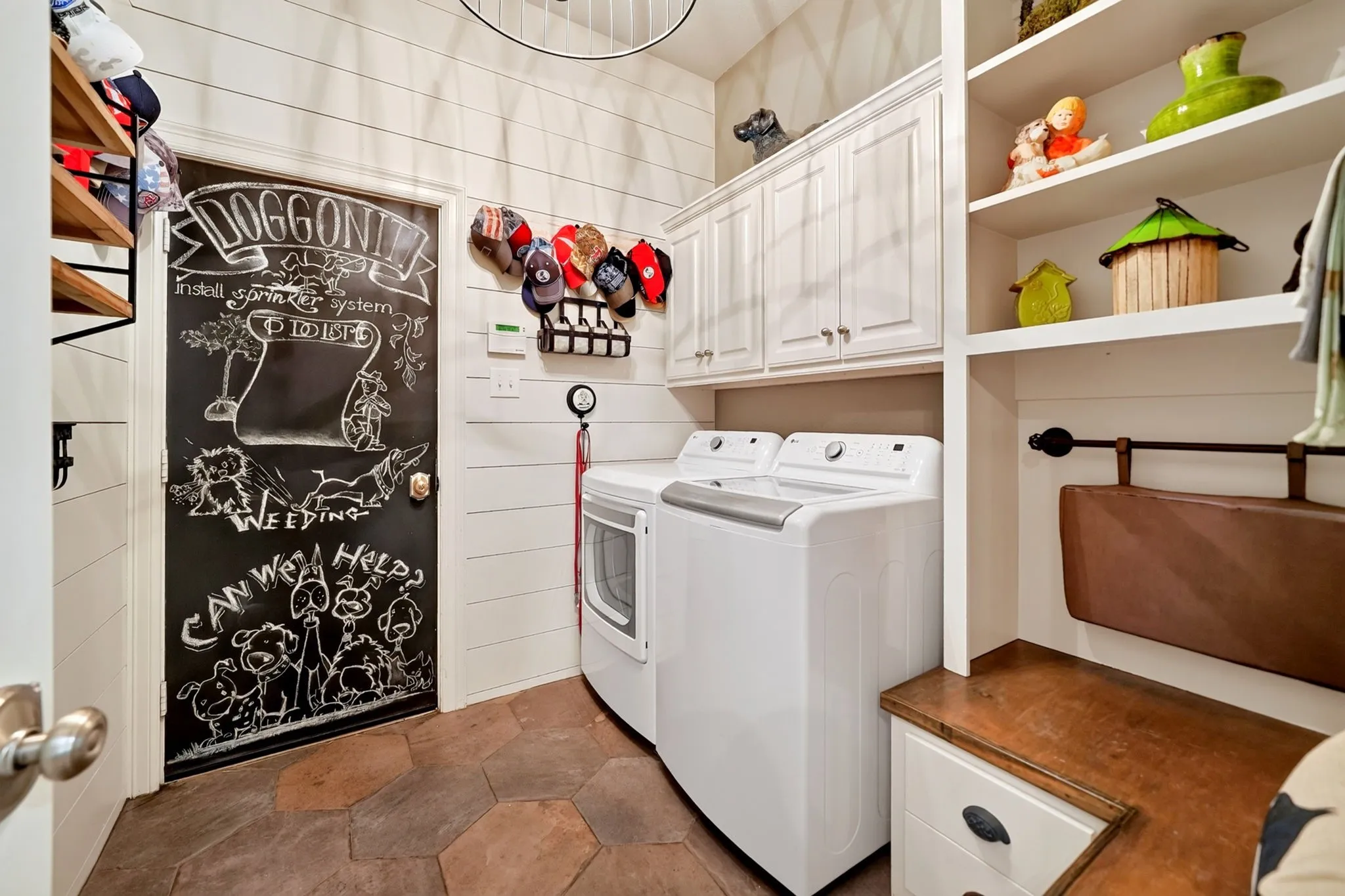 Utility area featuring hexagonal tile flooring, white shiplap walls, and built-in white cabinetry