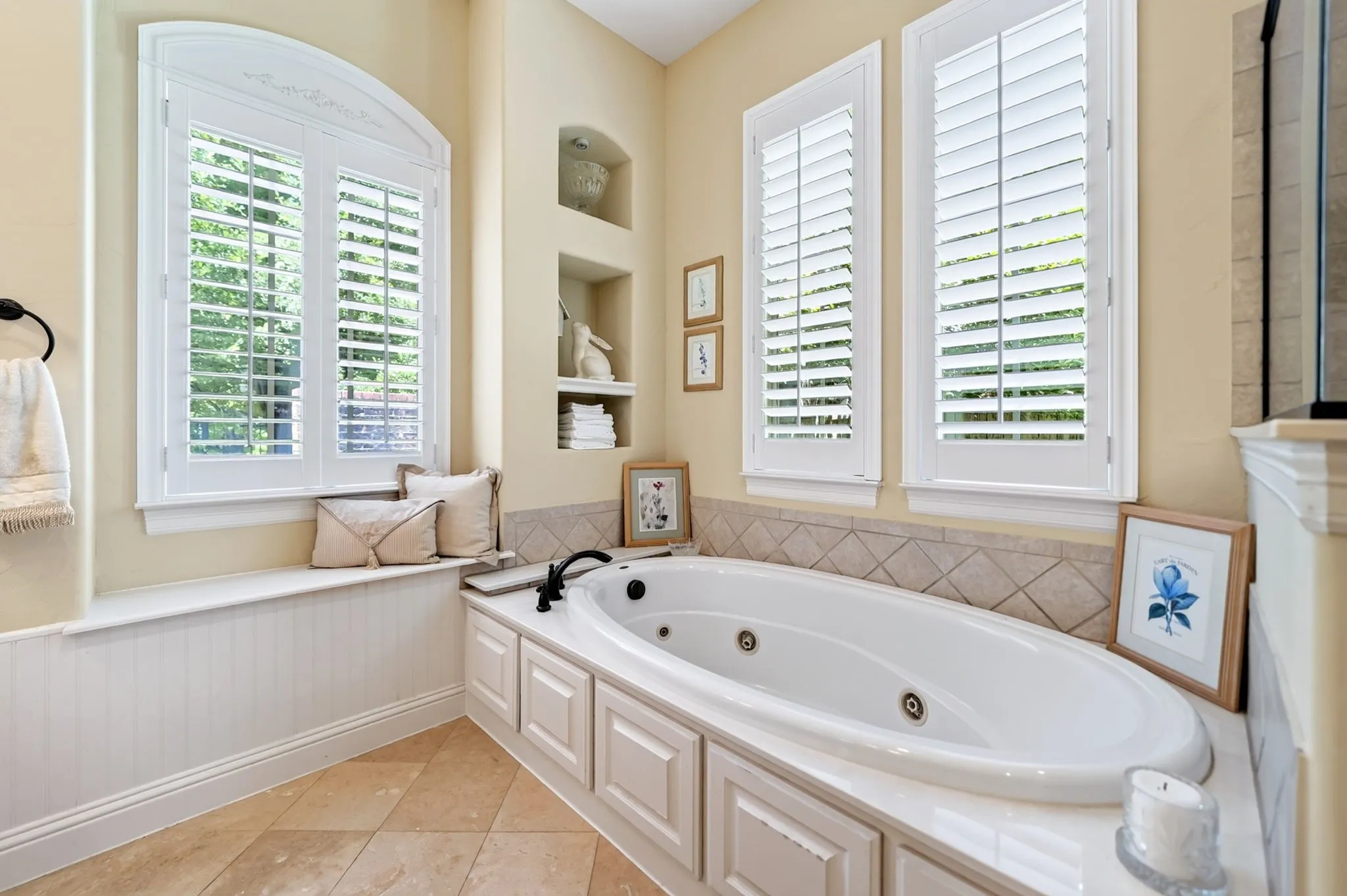Soaking tub featuring a tiled surround and built-in storage