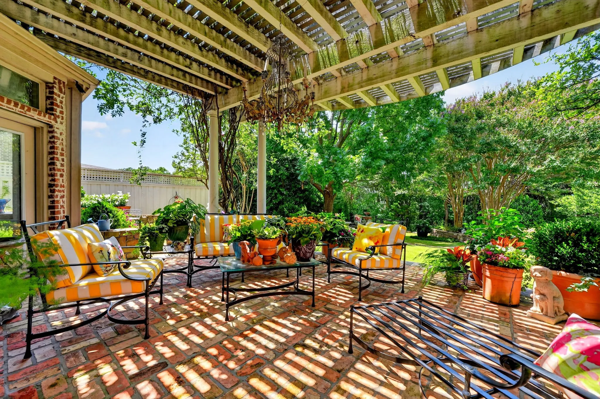 Brick paver patio featuring a wood pergola with a hanging chandelier