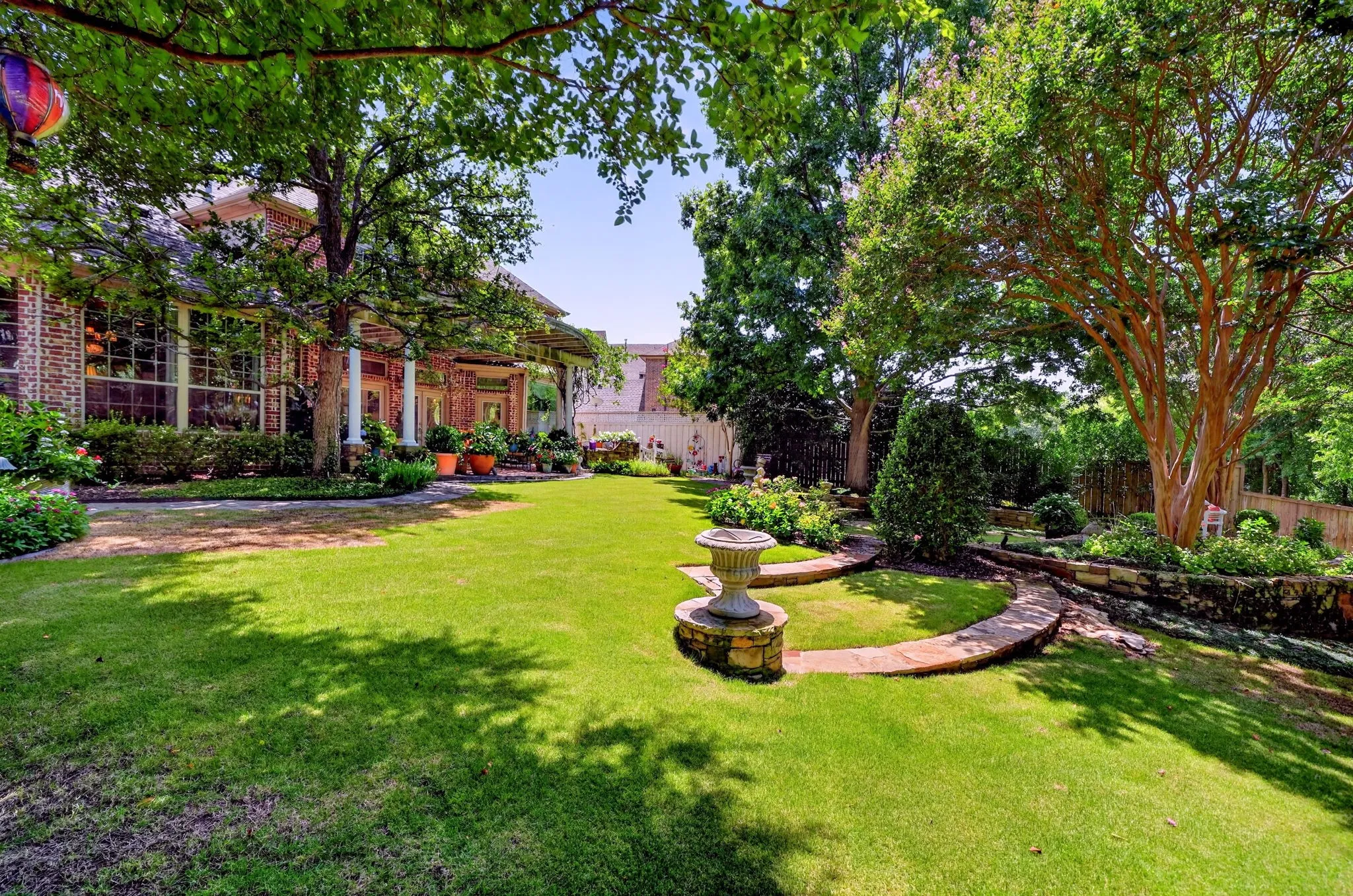 Expansive green lawn with mature trees providing ample shade