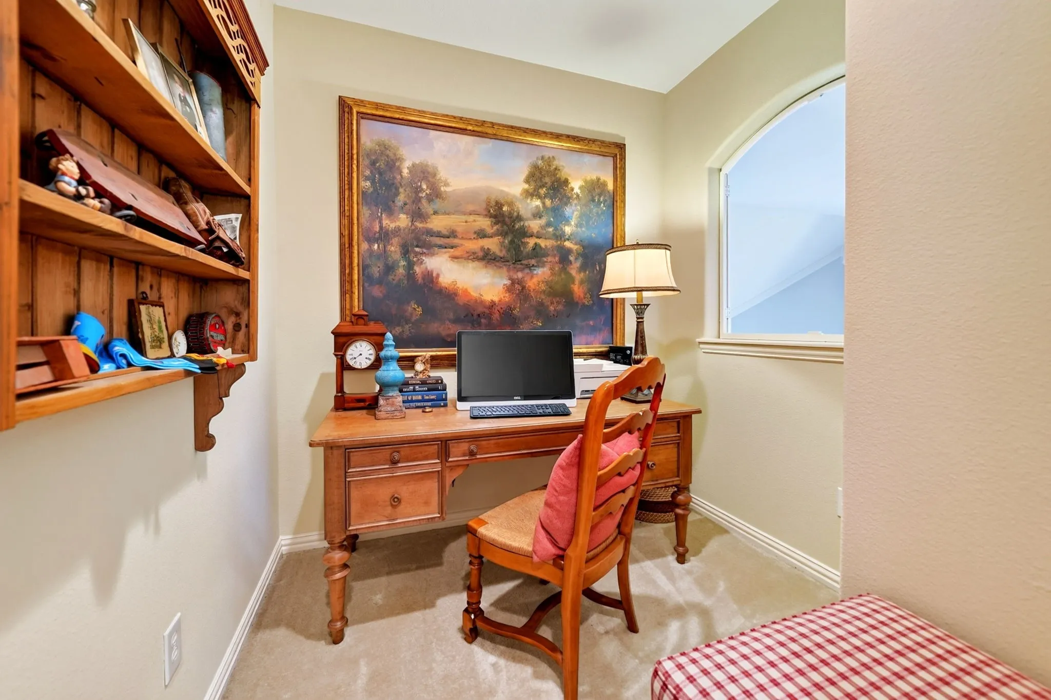 Dedicated niche space featuring an arched window opening, built-in wooden shelving, and soft carpeting
