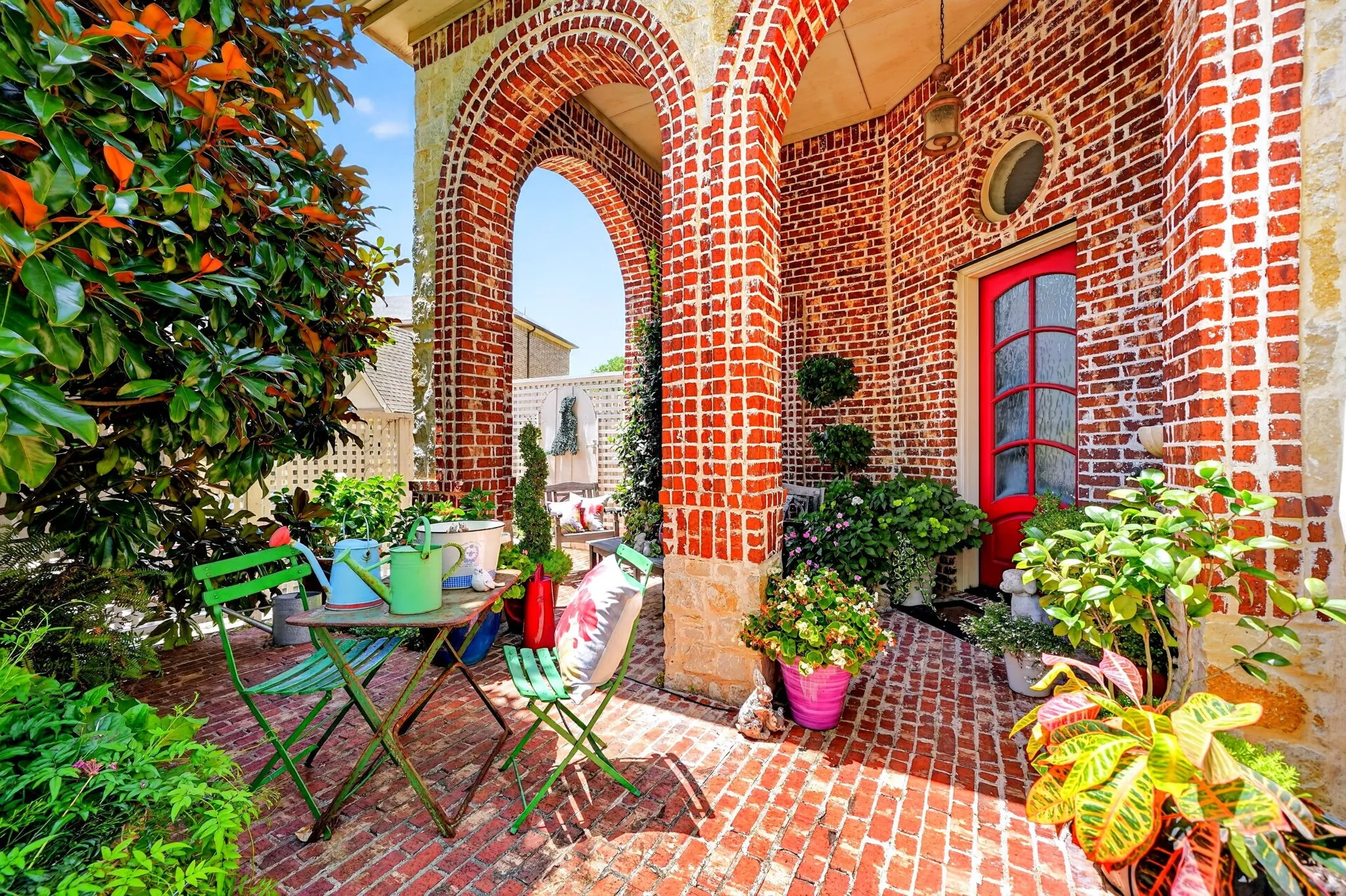 Brick exterior featuring arched doorways and a red entry door