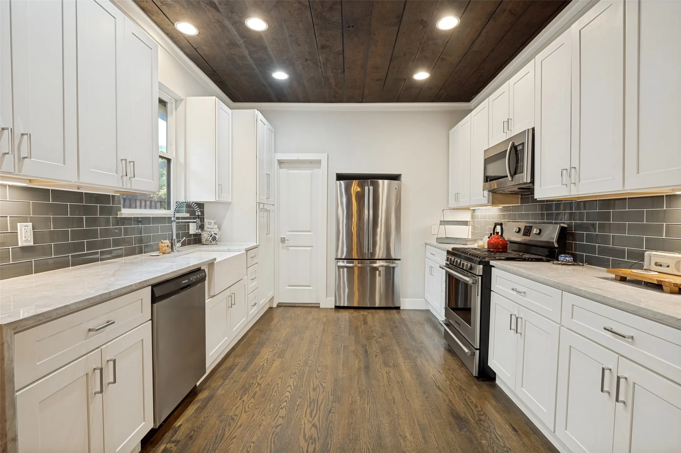 Featuring Marble Waterfall Counters and Glass Tile Backsplash