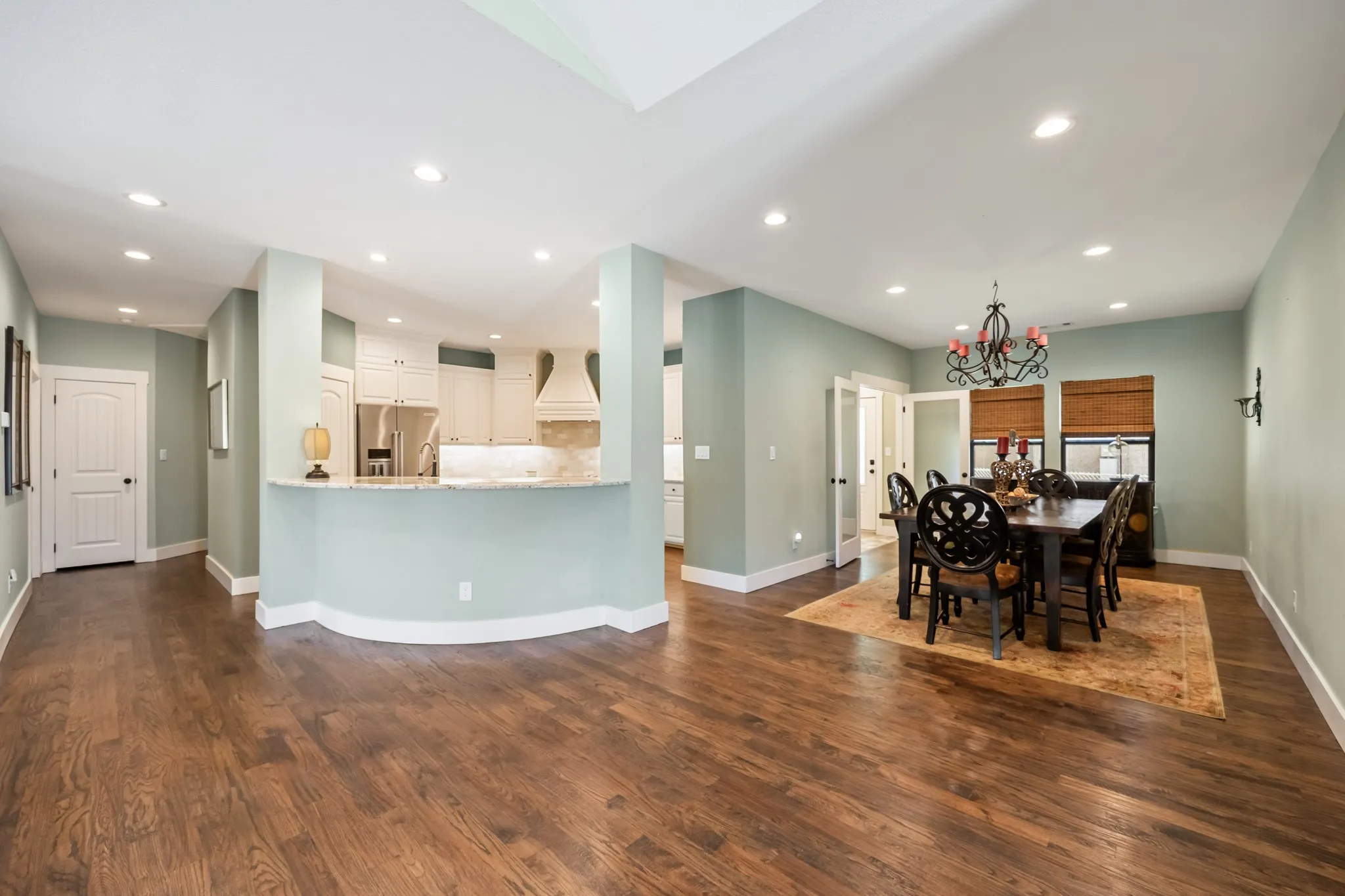 Hardwood flooring throughout, recessed lighting, built-in kitchen cabinetry, light-toned wall paint, and a built-in kitchen range hood