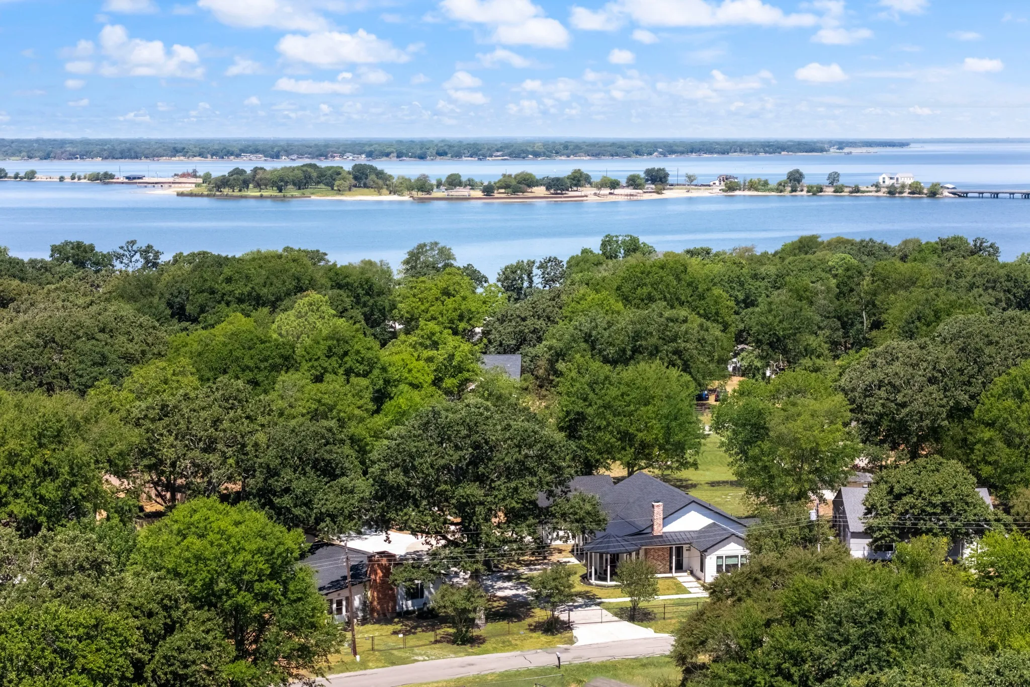 Extensive natural landscaping with mature trees and a waterfront backdrop