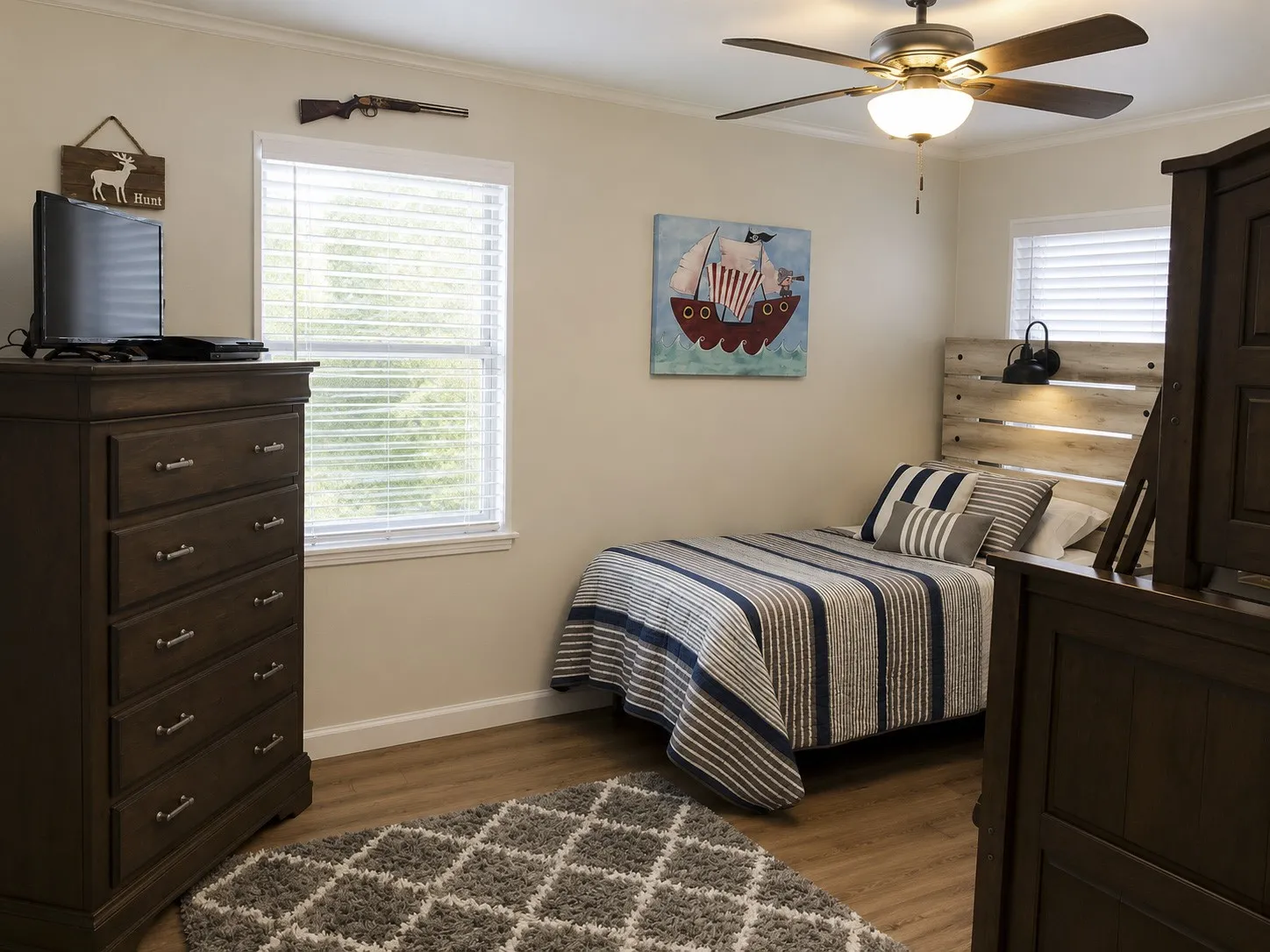 Wood-finish flooring, single window with blinds, ceiling fan with integrated lighting, crown molding, and a light-toned wall color