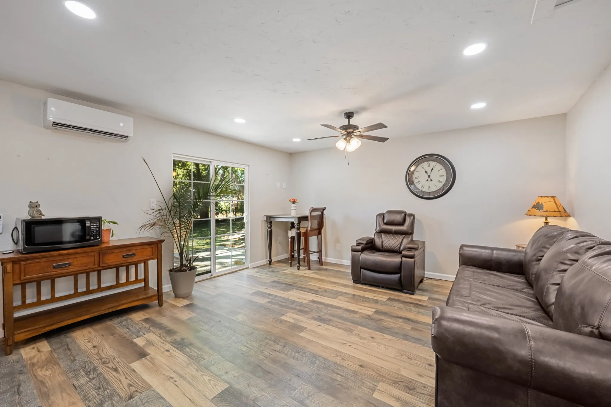 Recessed lighting, wood-finish flooring, ceiling fan, and sliding glass door
