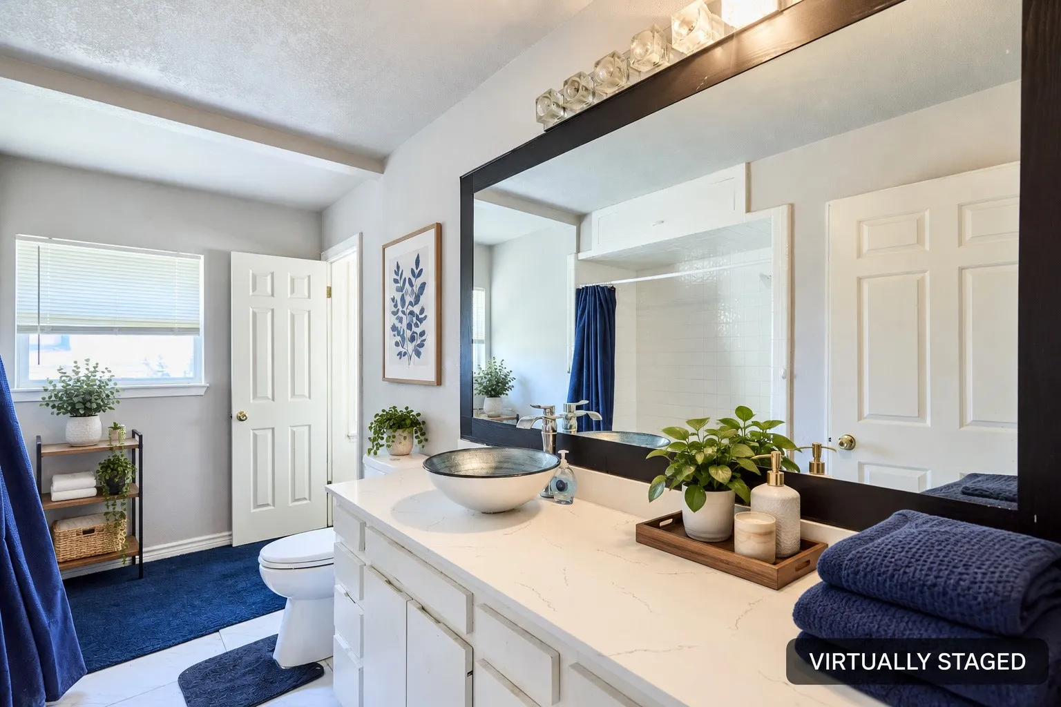 White vanity with a vessel sink, a large mirror, and overhead lighting