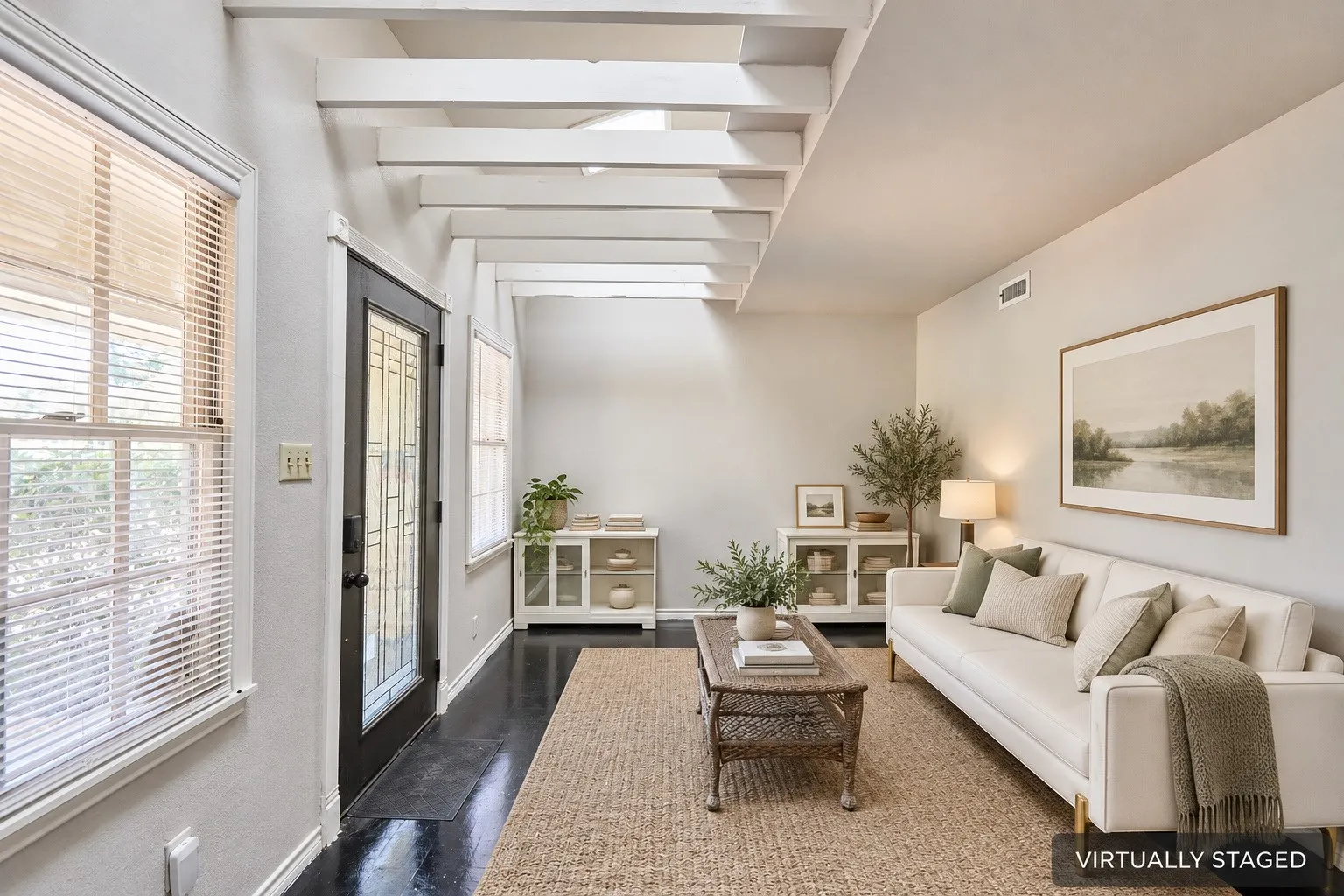 Exposed ceiling beams, dark wood-finish flooring, and a decorative glass entry door enhance this living space