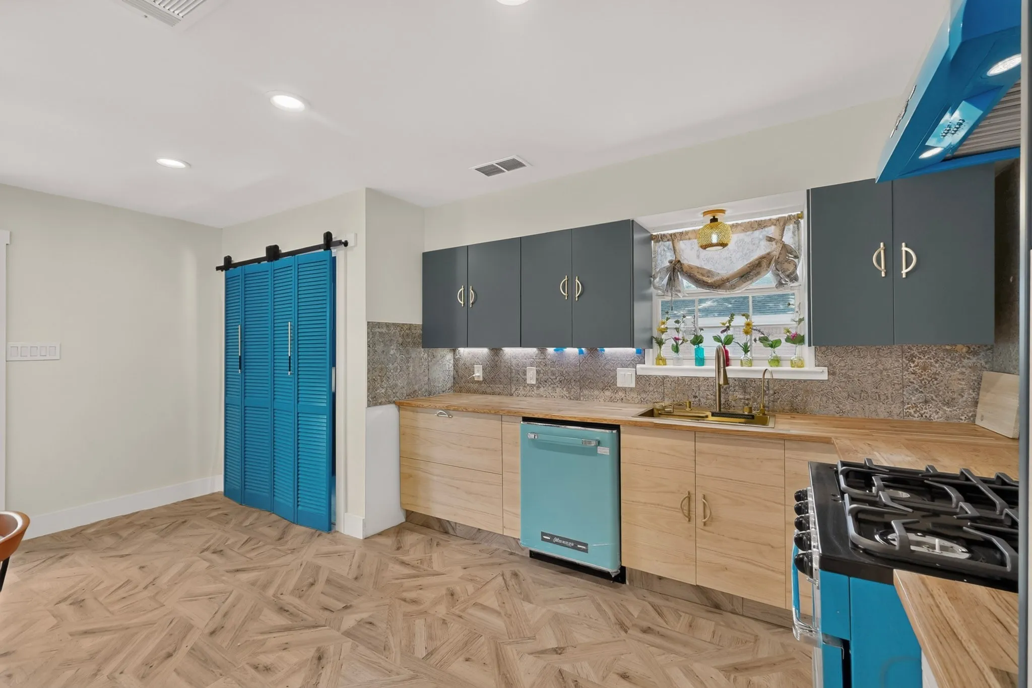 Kitchen featuring wood-finish countertops, under-cabinet lighting, and a unique backsplash
