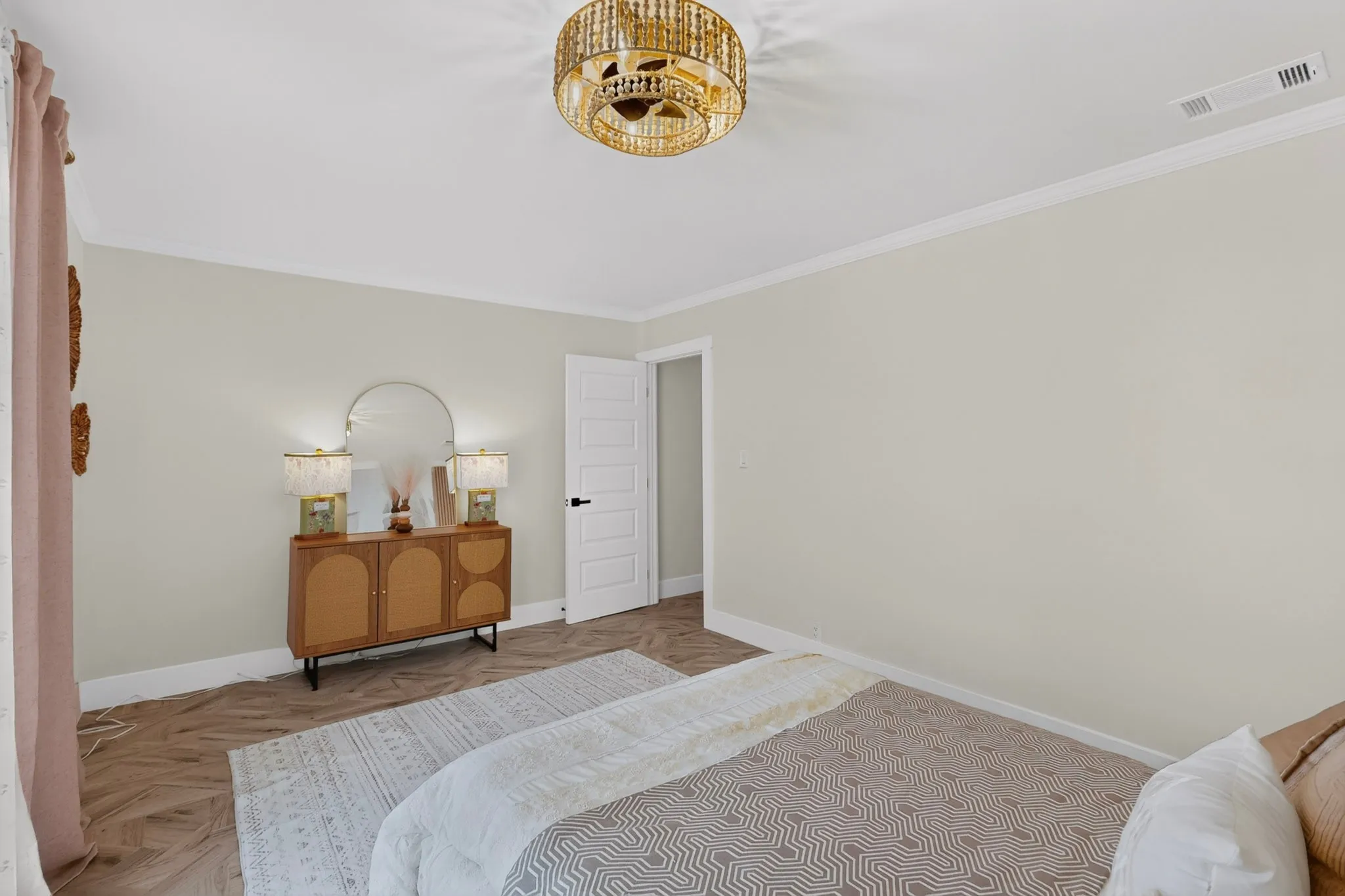 Bedroom featuring herringbone wood-finish flooring, white trim, and a decorative ceiling fixture
