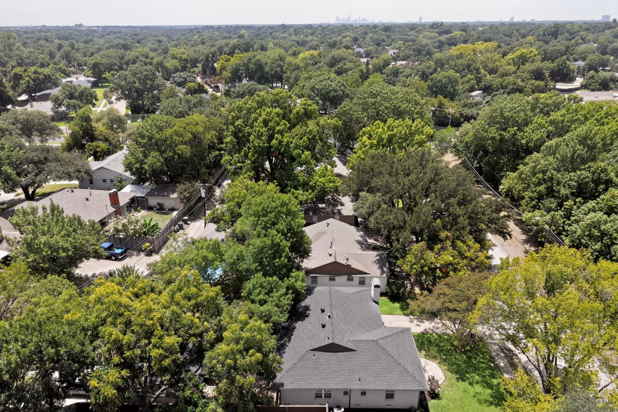 Aerial perspective showcasing residential properties amidst abundant mature trees