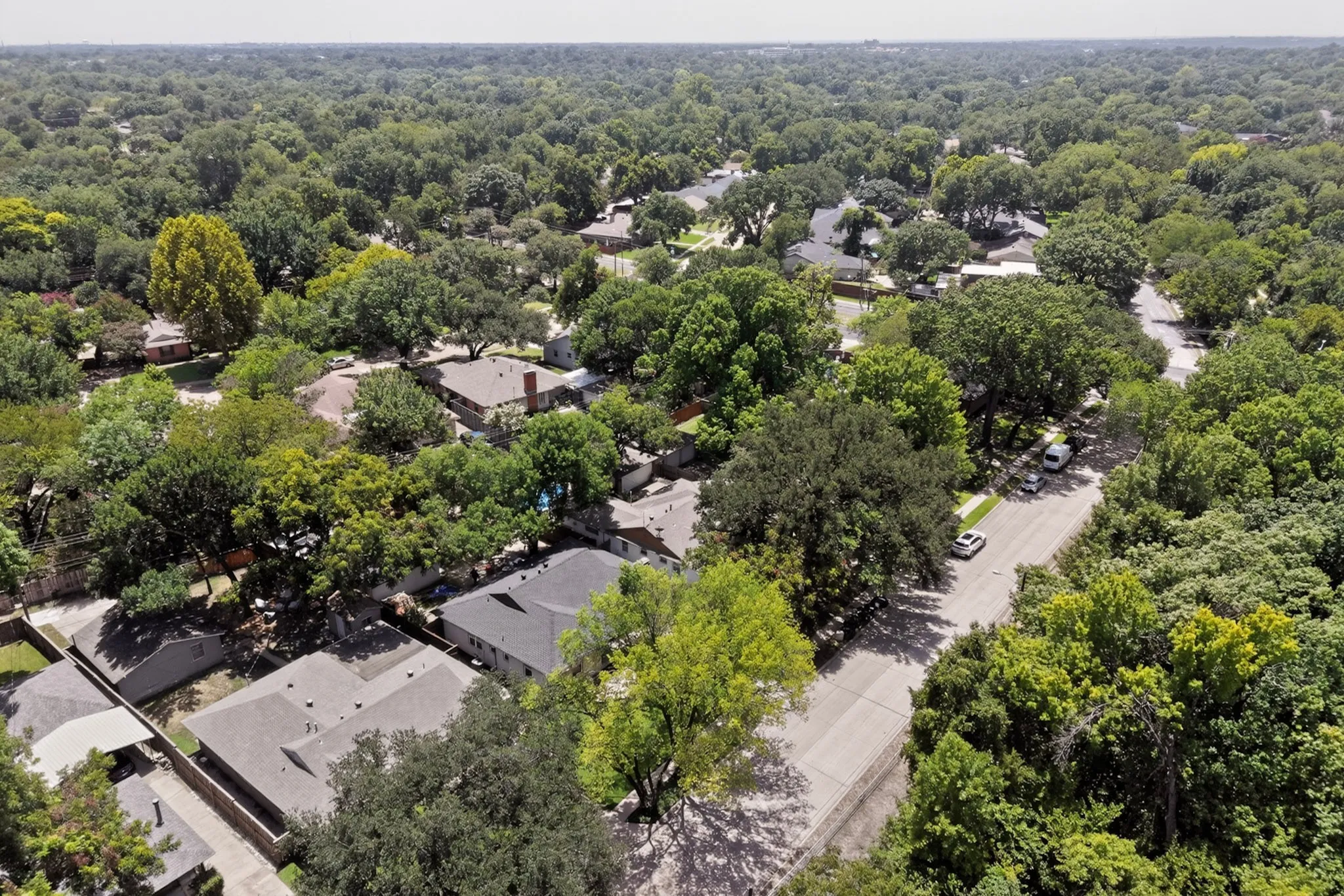 Aerial overview of a residential neighborhood with extensive mature tree canopy