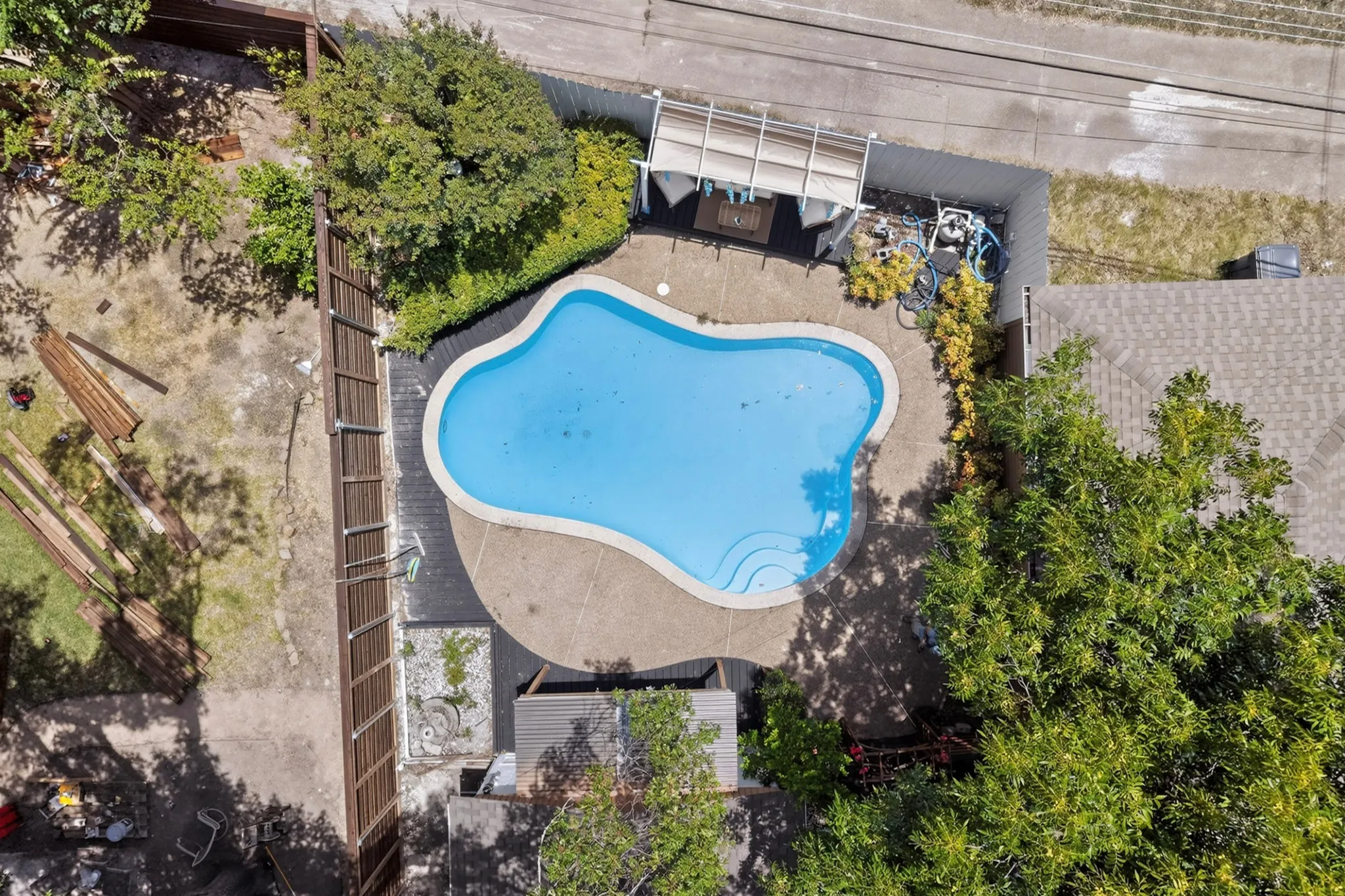 Freeform swimming pool with integrated steps, surrounded by concrete decking