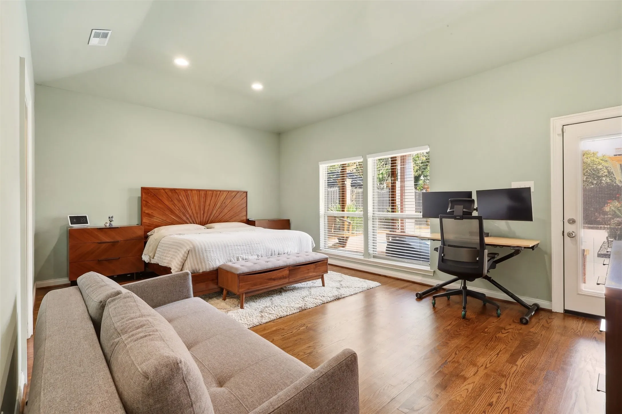 Spacious room with rich wood-finish flooring and a tray ceiling featuring a ceiling fan and recessed lighting