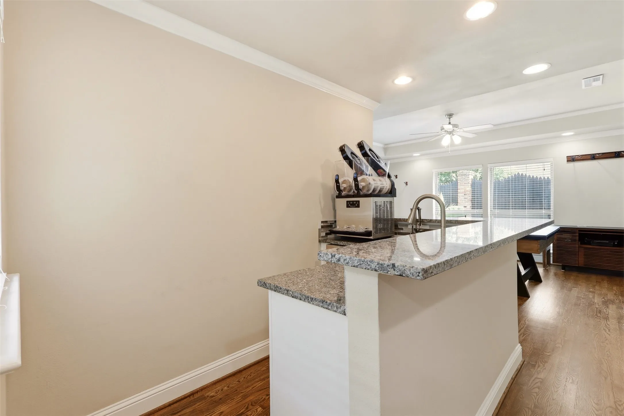 Kitchen island with granite countertop and integrated sink featuring a gooseneck faucet
