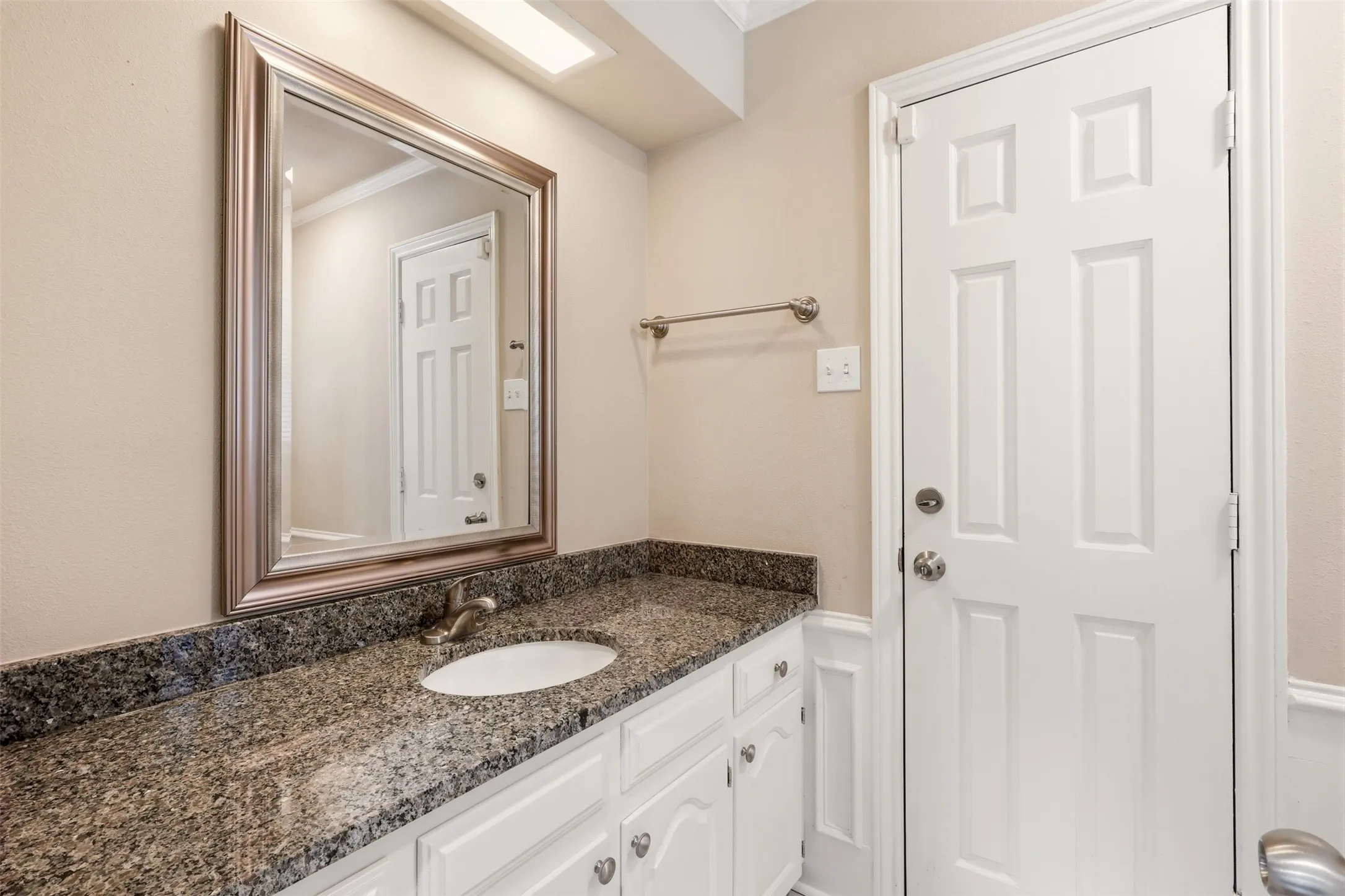 Hardwood-style flooring throughout the main living area, featuring an open-concept layout with a kitchen, a breakfast bar, and stainless steel appliances