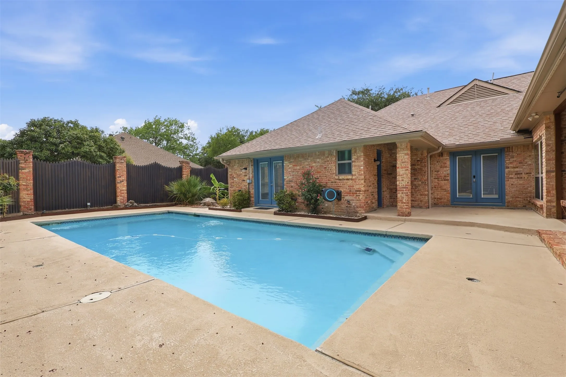 Rectangular swimming pool with integrated steps and a surrounding concrete patio