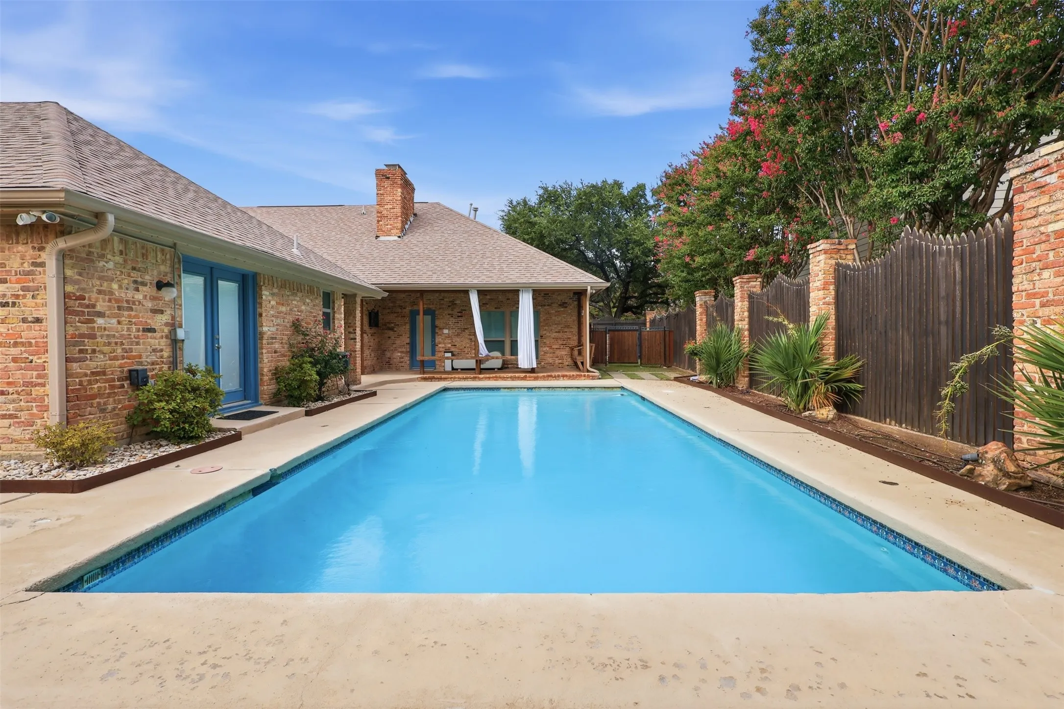 Rectangular in-ground swimming pool surrounded by a concrete patio
