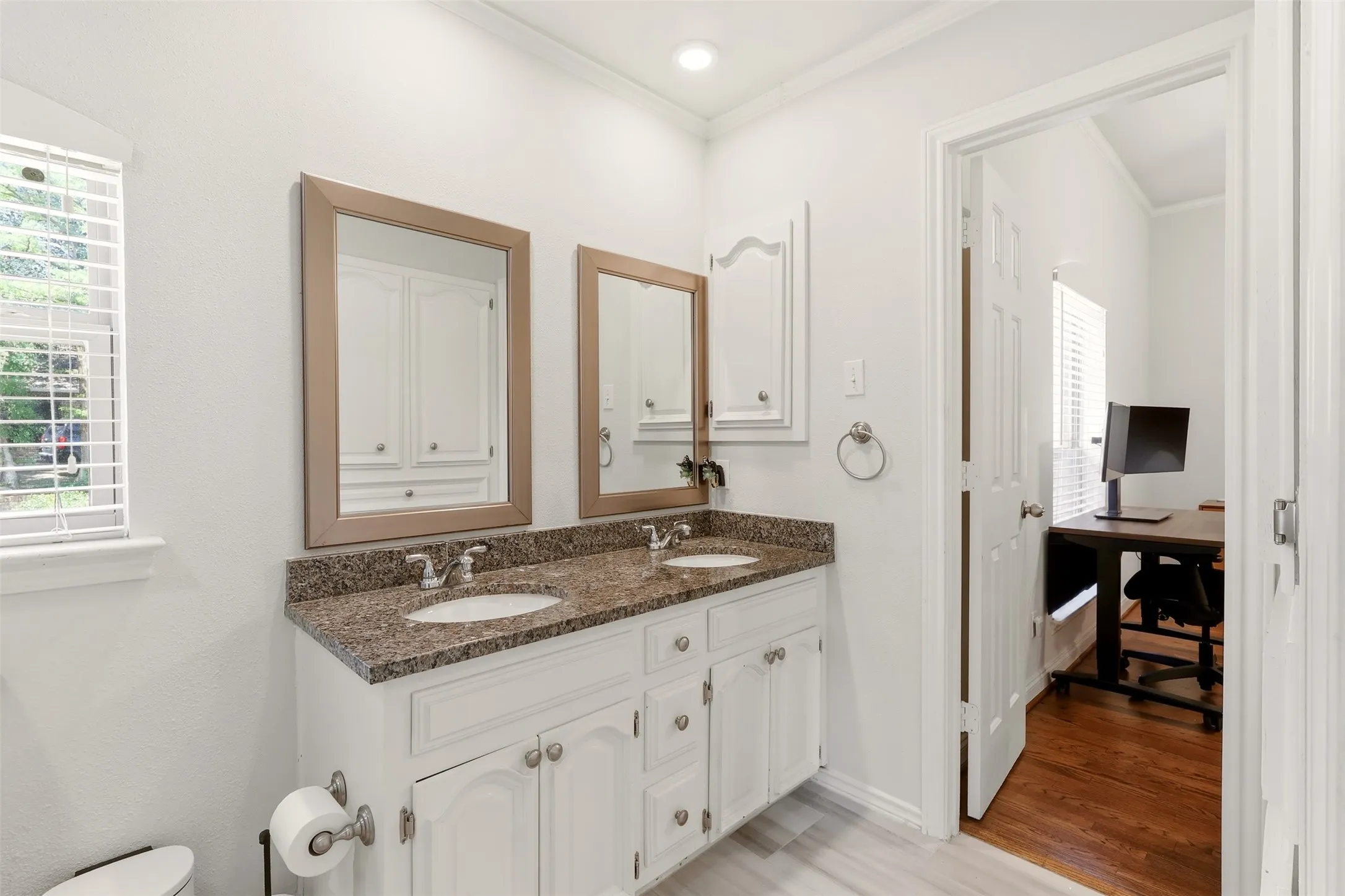 Laundry area featuring a utility sink with a gooseneck faucet, light-toned stone countertop, white shaker-style cabinetry, and light wood-finish flooring