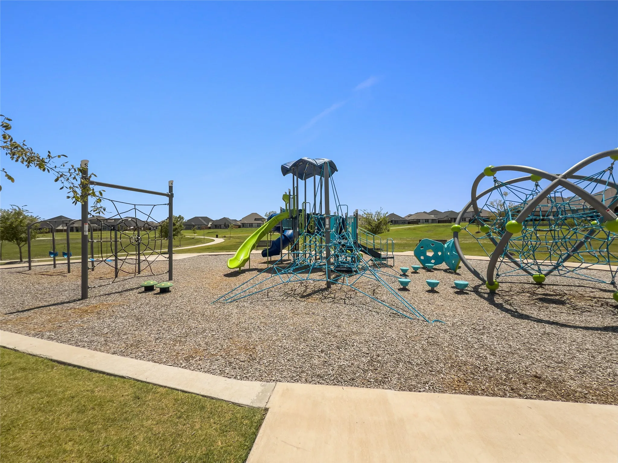 Community amenity featuring a playground with multiple structures, including slides and climbing elements