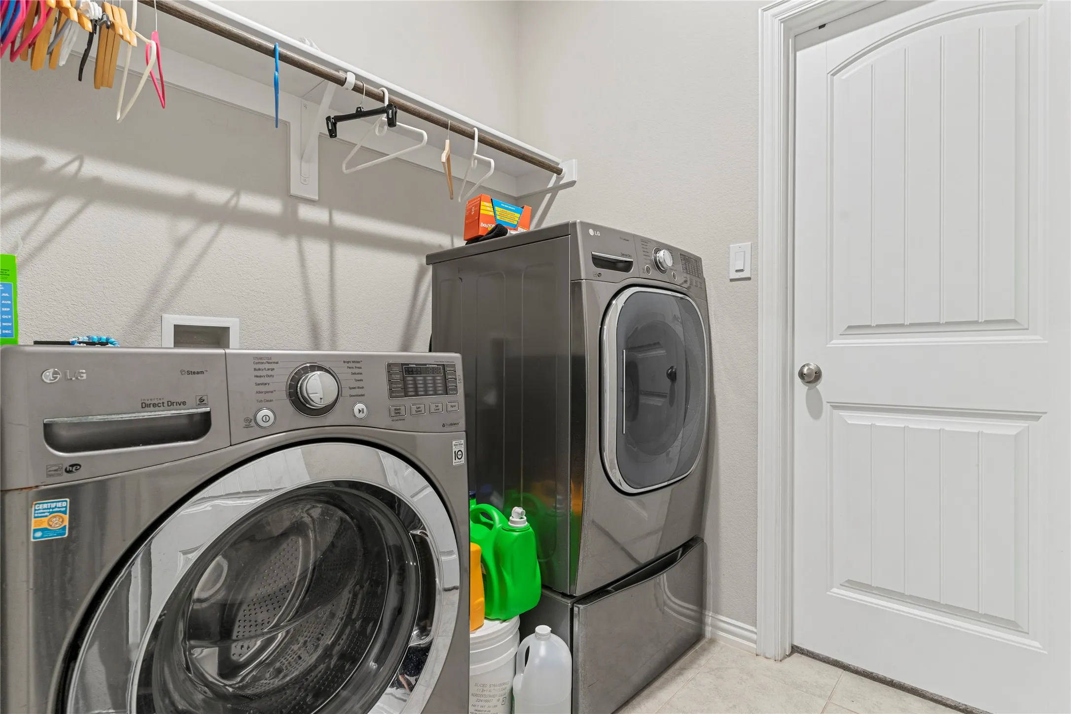 Dedicated laundry area featuring light gray walls and a built-in hanging rod