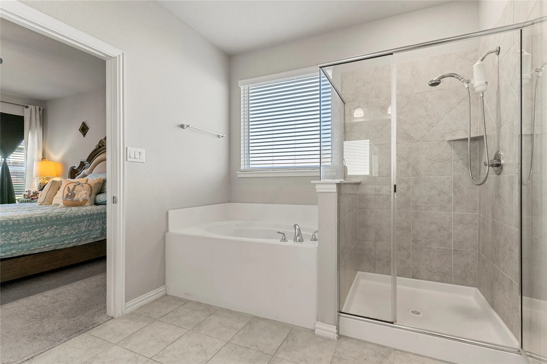 Contemporary bathroom featuring a built-in soaking tub with deck-mounted faucet and an enclosed shower with tile surround, built-in niche, and glass door