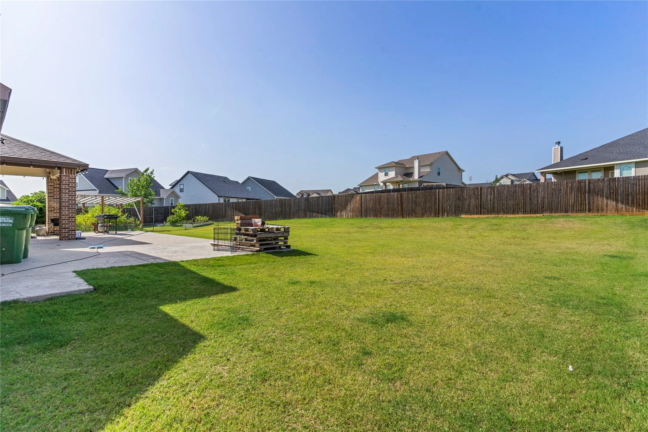 Expansive green lawn with a privacy fence