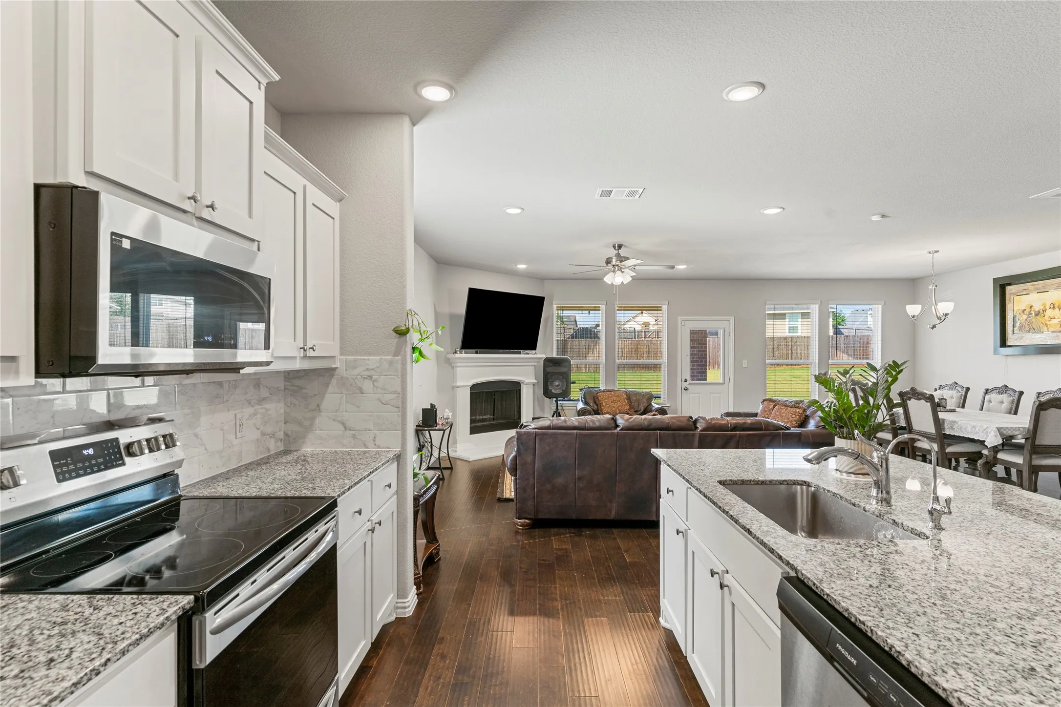 Kitchen featuring white shaker cabinetry, stainless steel appliances, speckled countertops, and a subway tile backsplash