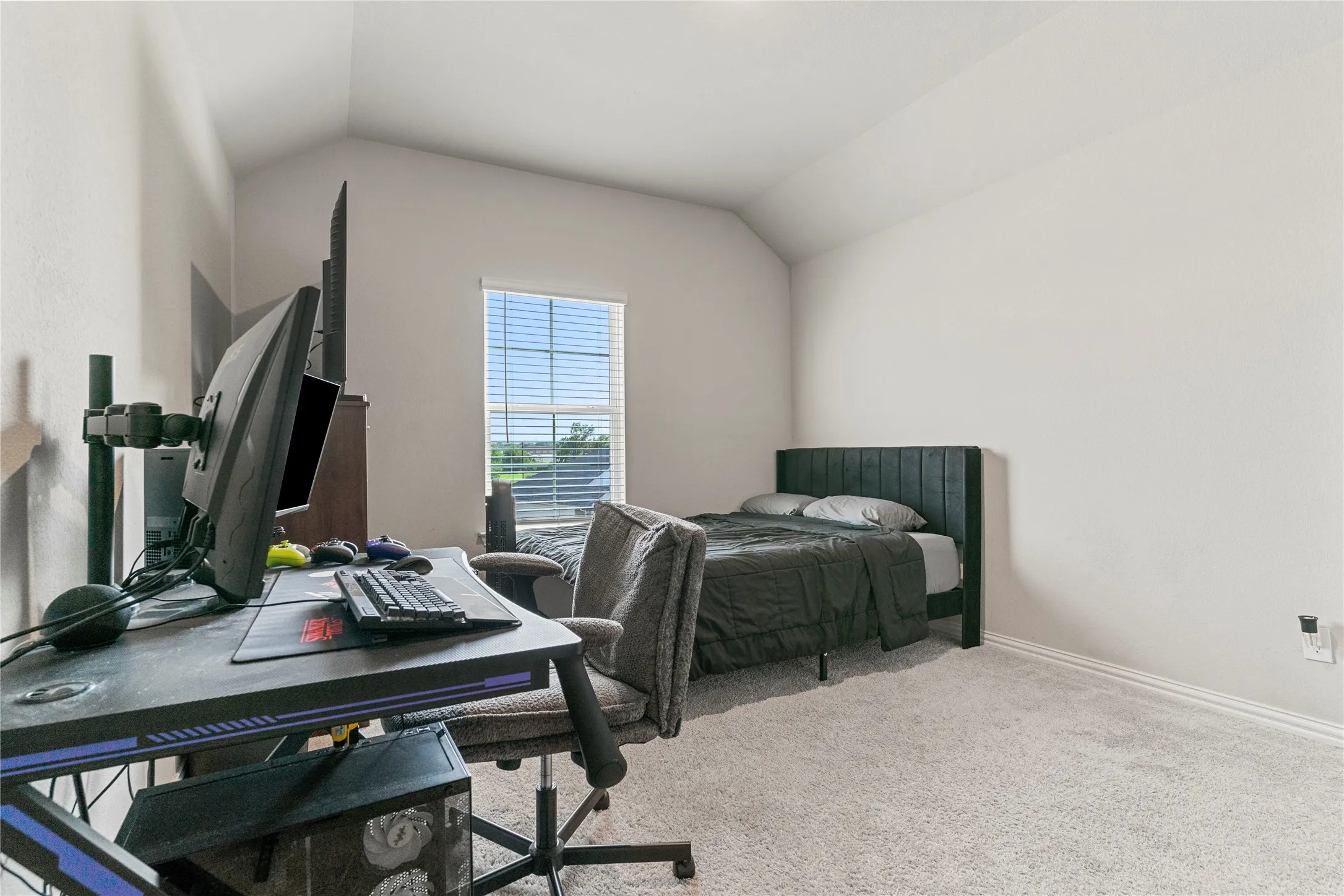 Carpeted room with a vaulted ceiling