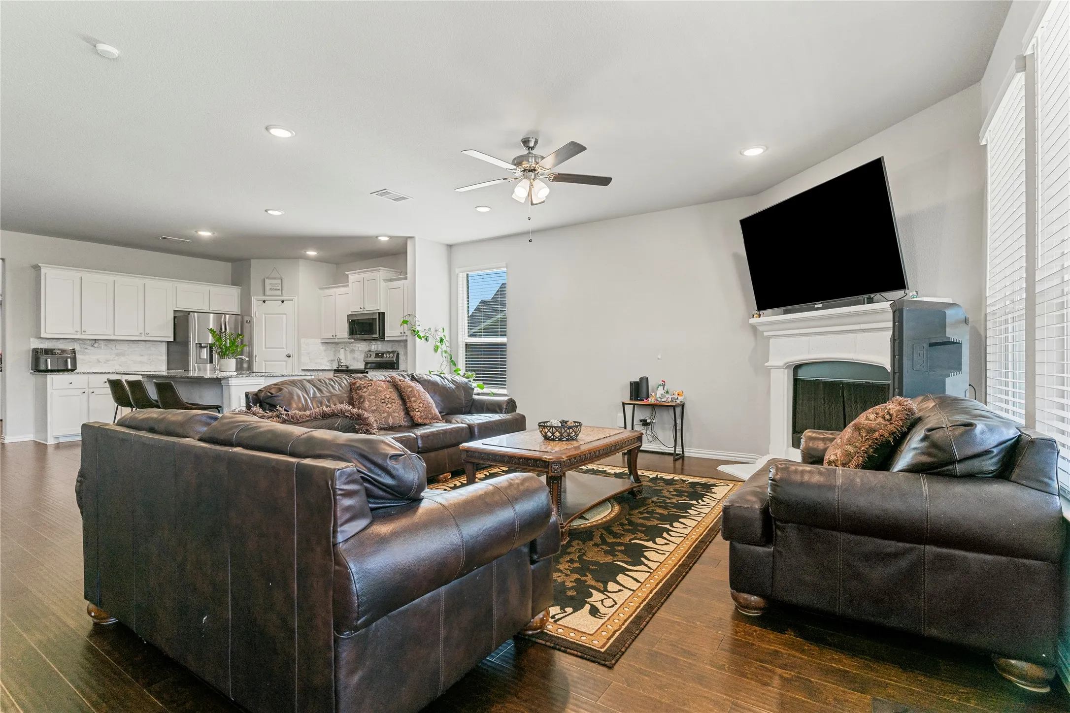 Open-concept living area featuring dark wood-finish flooring, recessed lighting, and a ceiling fan