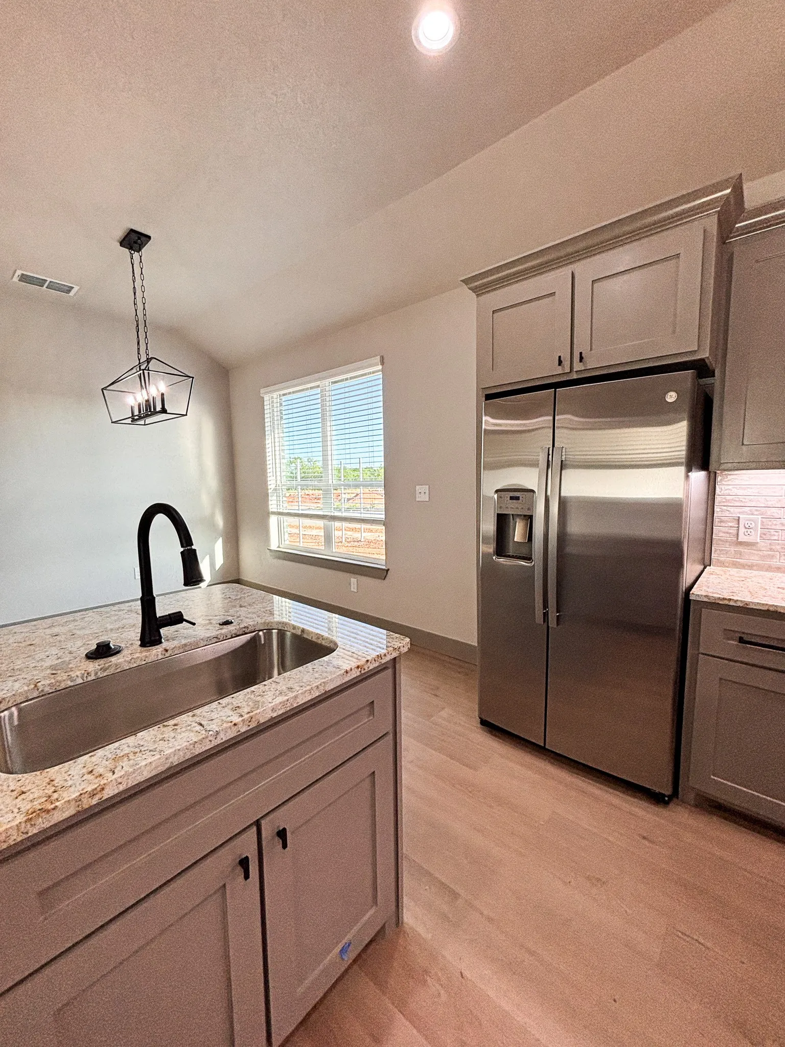 Kitchen island featuring a stainless steel undermount sink and a matte black gooseneck faucet