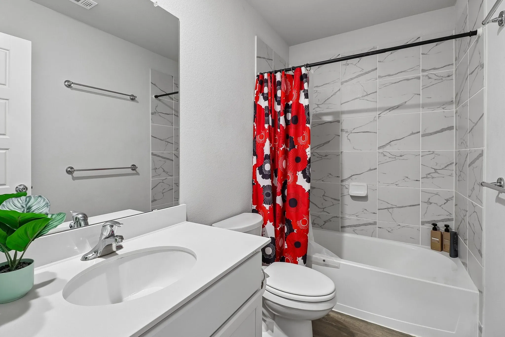 Bathroom featuring a spacious vanity with an integrated sink, polished chrome faucet, and a large wall-mounted mirror