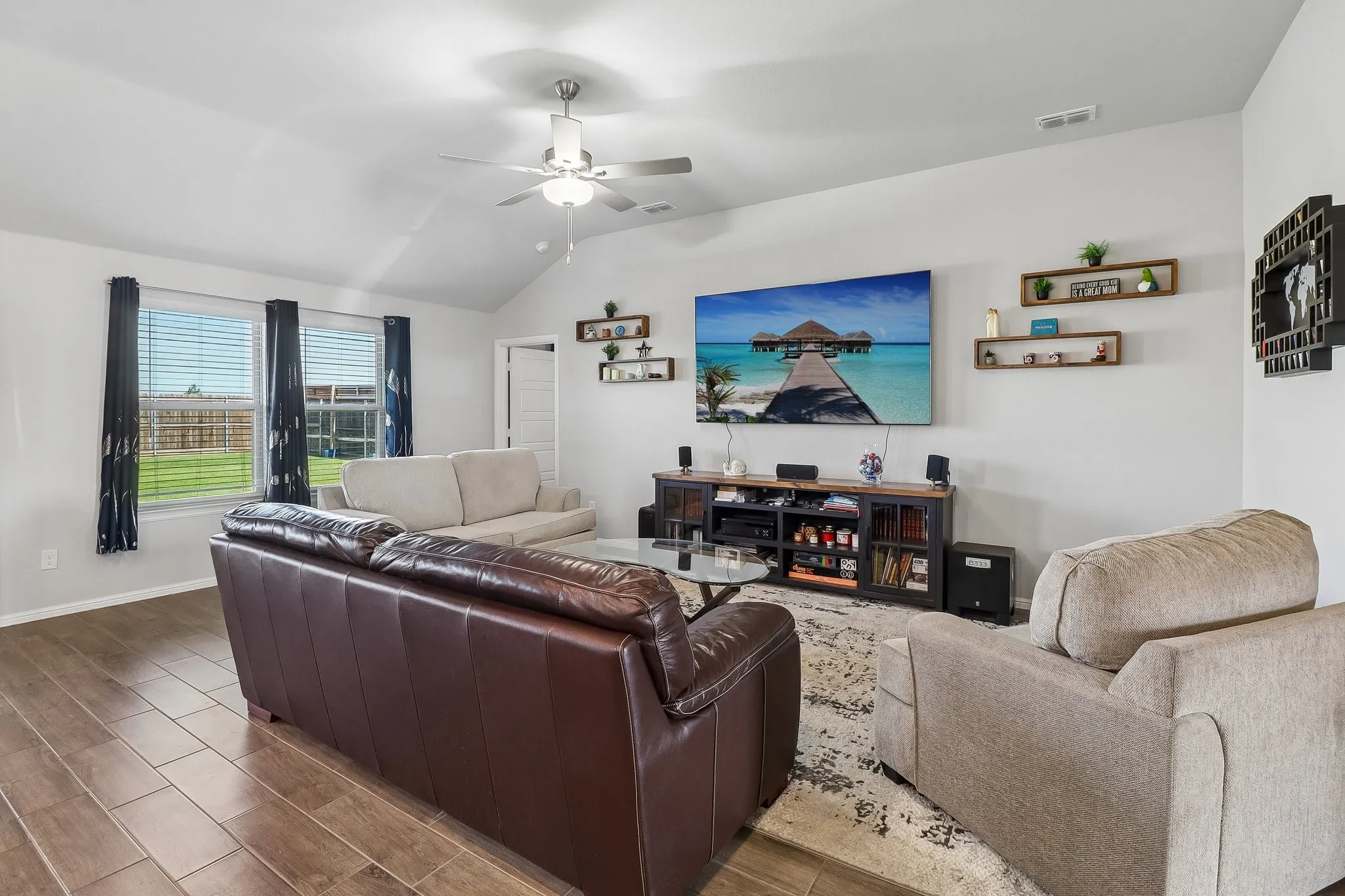 Spacious living area featuring vaulted ceilings and wood-finish tile flooring