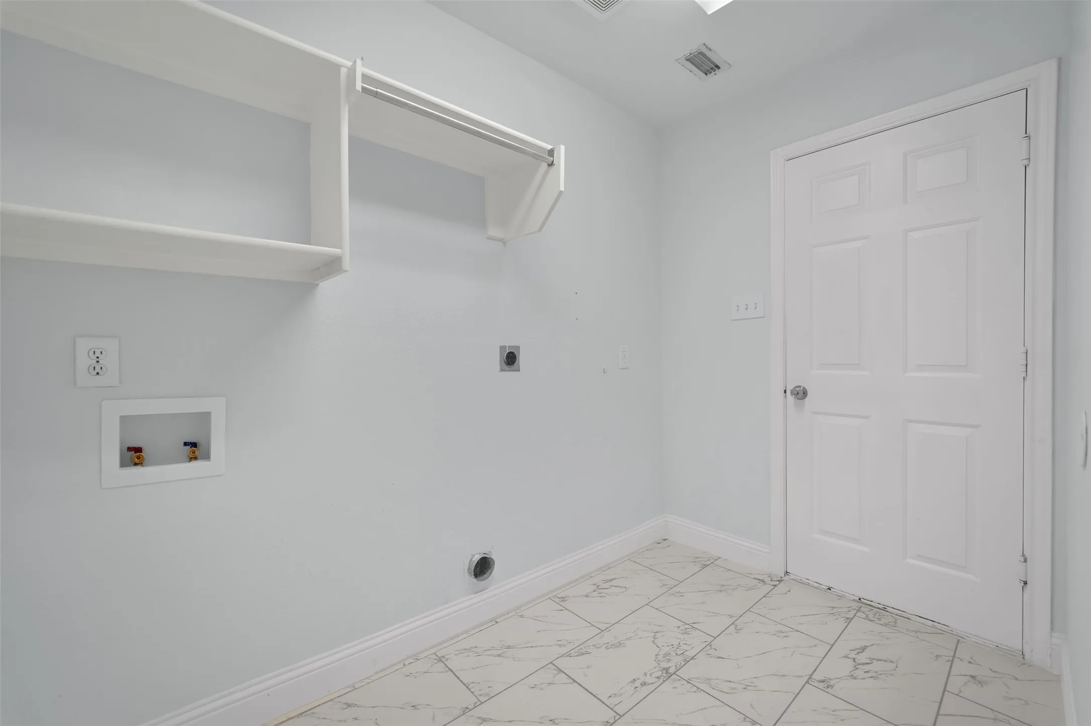 Utility space featuring white walls and a paneled door