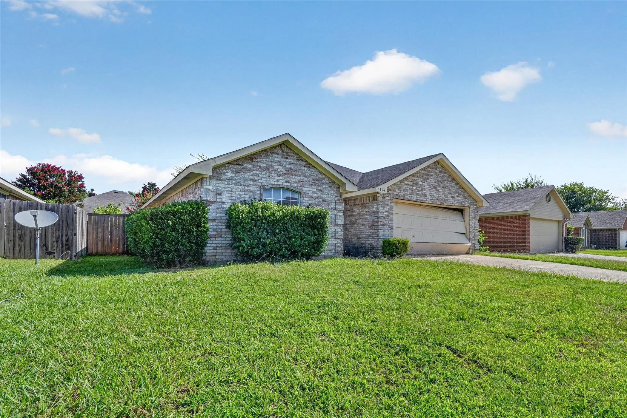Stone veneer facade with a single-car garage and arched window