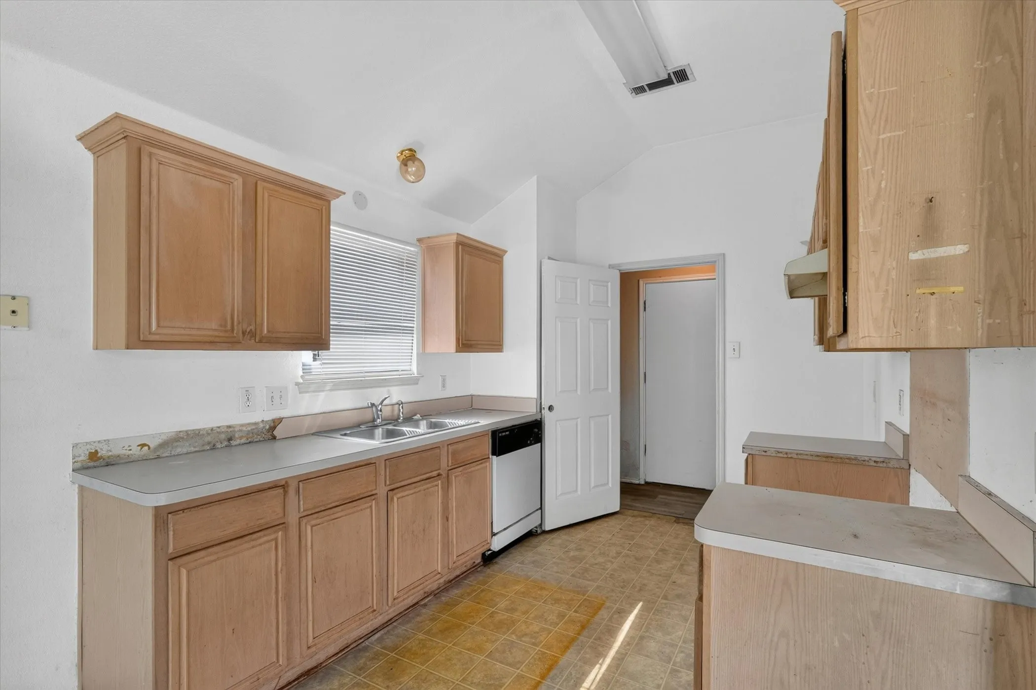 Kitchen featuring light wood cabinetry and light-toned countertops