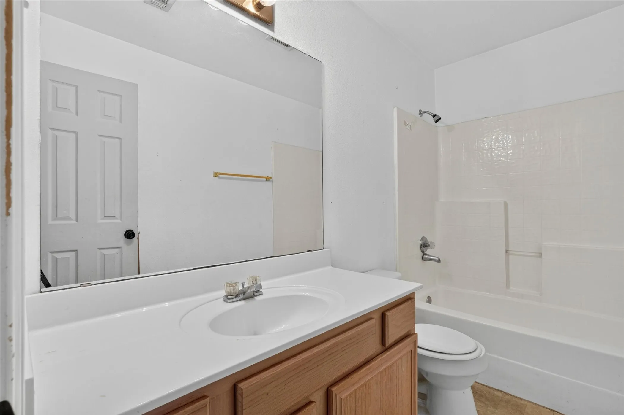 Bathroom featuring a light wood-finish vanity with a white countertop and integrated sink