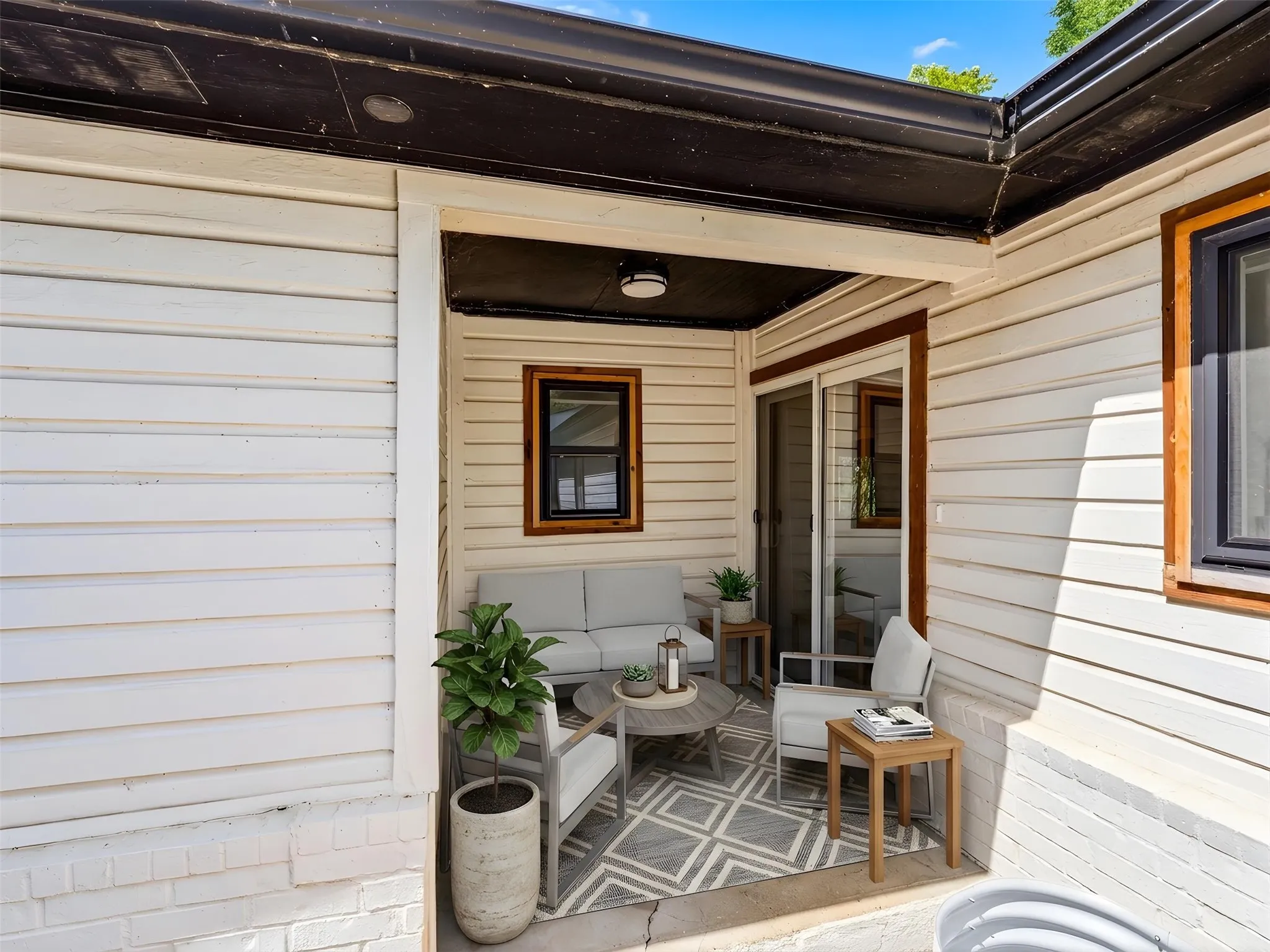 Covered patio area featuring white horizontal siding and a sliding glass door
