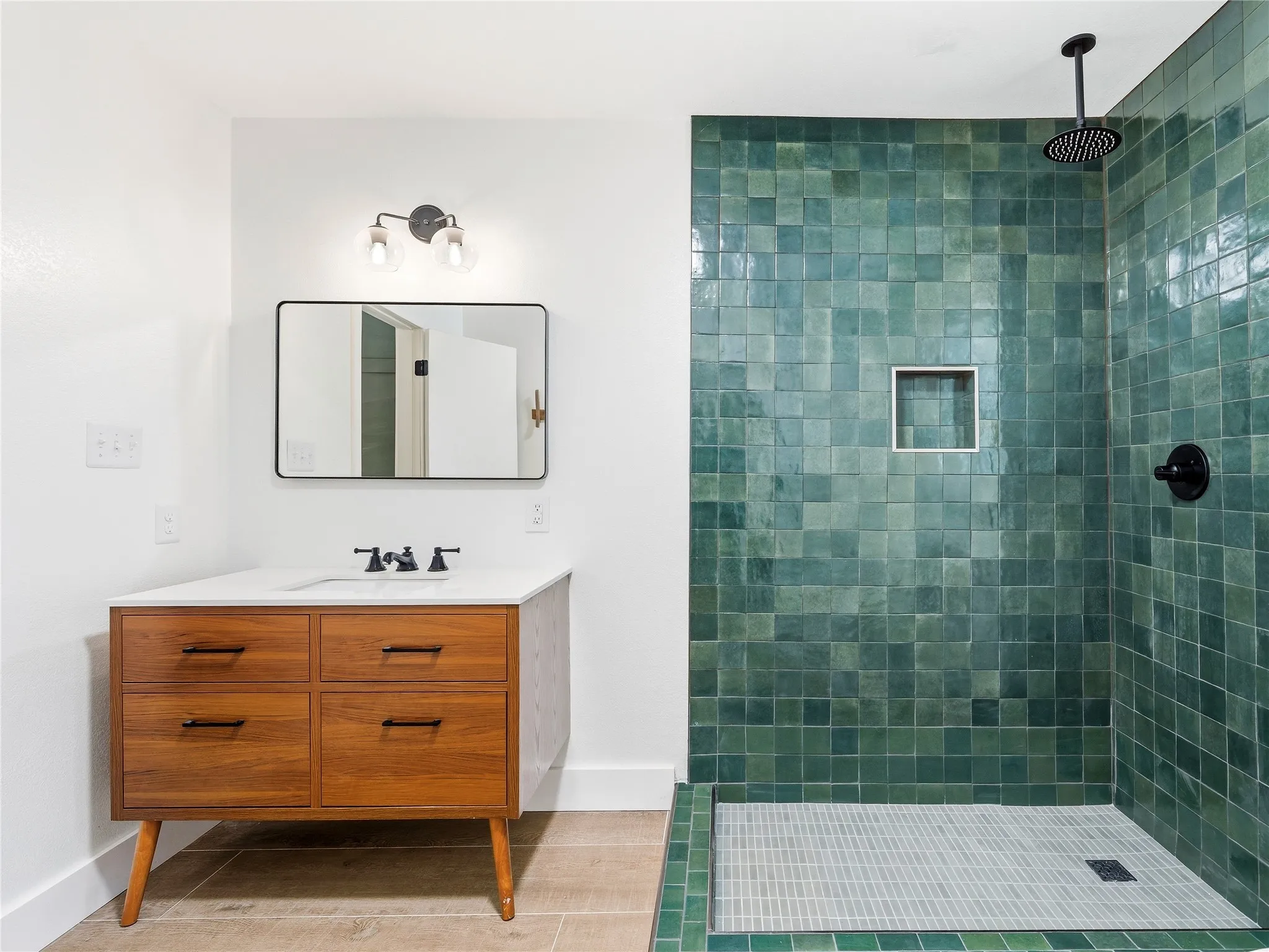 Bathroom featuring a wood-finish vanity with drawer storage, a white countertop, and a recessed sink