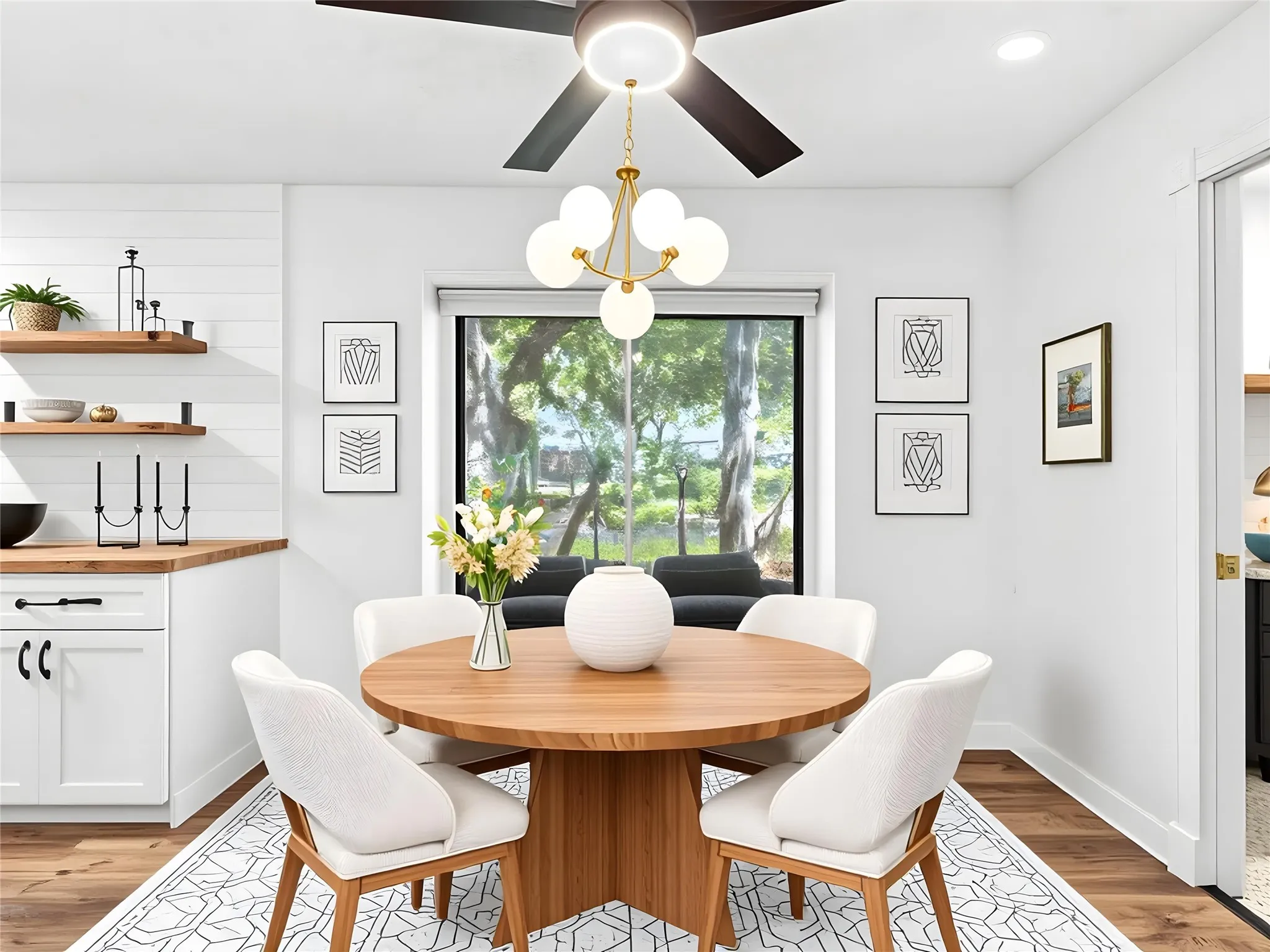 Dining area featuring wood-finish flooring, a contemporary ceiling fan, and a modern chandelier