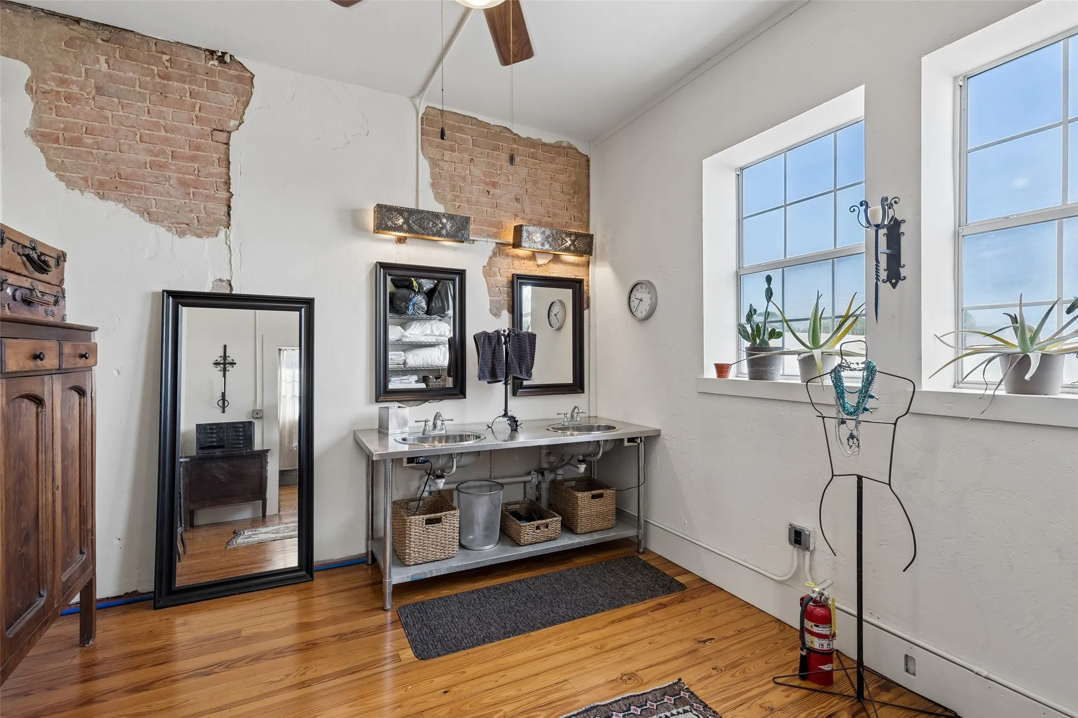 Exposed brick accents complement light-colored walls and wood-finish flooring